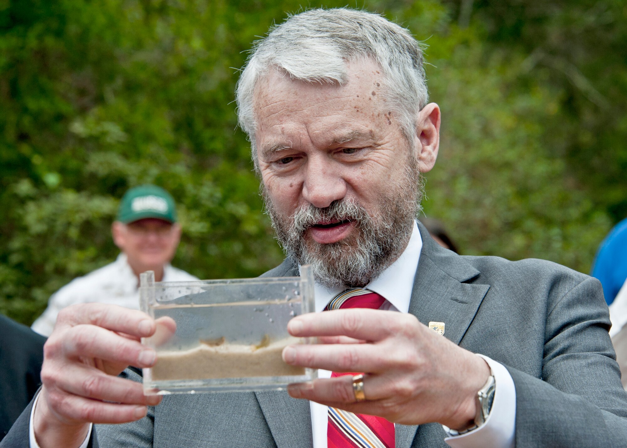 Rowan Gould takes a look at a container of Okaloosa darters March 28, 2011, at Eglin Air Force Base, Fla. The small fish, whose habitat is almost exclusively on the Eglin ranges, became the first fish on Defense Department land to be reclassified from "endangered" to "threatened". Gould is the director of U.S. Fish and Wildlife Service. (U.S. Air Force photo/ Samuel King Jr.)
