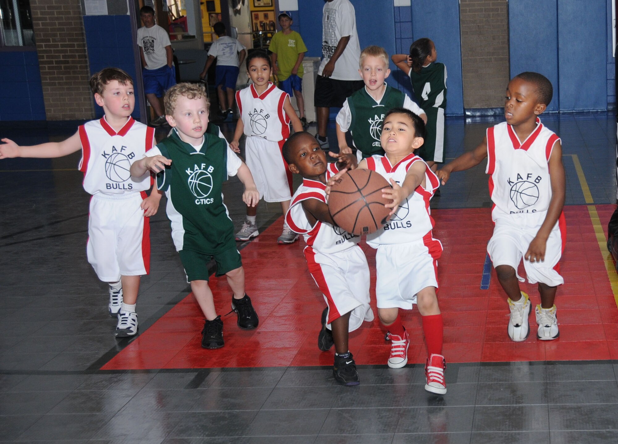 Bulls teammates Ajani Washington, left, and Gabriel Bautista both hustle to recover a
ball during Saturday’s youth center basketball game against the Celtics while other players move forward around them — from left, Ryan Gottrich, Tristan Fisher, Gabrielle Kamarakafego, Joshua Bowman and Messiah Washington. Ajani, 4, and Messiah, 5, are the sons of Tech. Sgts. Jason and Tomeika Washington, 333rd Training Squadron. Ryan, 5, is the son of Lt. Col. Daniel and Ainsley Gottrich, 338th TRS commander. Tristan, 5, is the son of Master Sgt. Anthony and Holly Fisher, 81st Training Group. Gabrielle, 5, is the daughter of Master Sgt. Jakelyne Kamarakafego, 335th TRS. Gabriel, 4, is the son of Staff Sgts. Rose Bautista, 81st Surgical Operations Squadron, and Mark Bautista, 81st Medical Operations Squadron. Joshua, 6, is the son of Capt. Ronny and Ramona Bowman, 81st Aerospace Medicine Squadron.  (U.S. Air Force photo by Kemberly Groue)