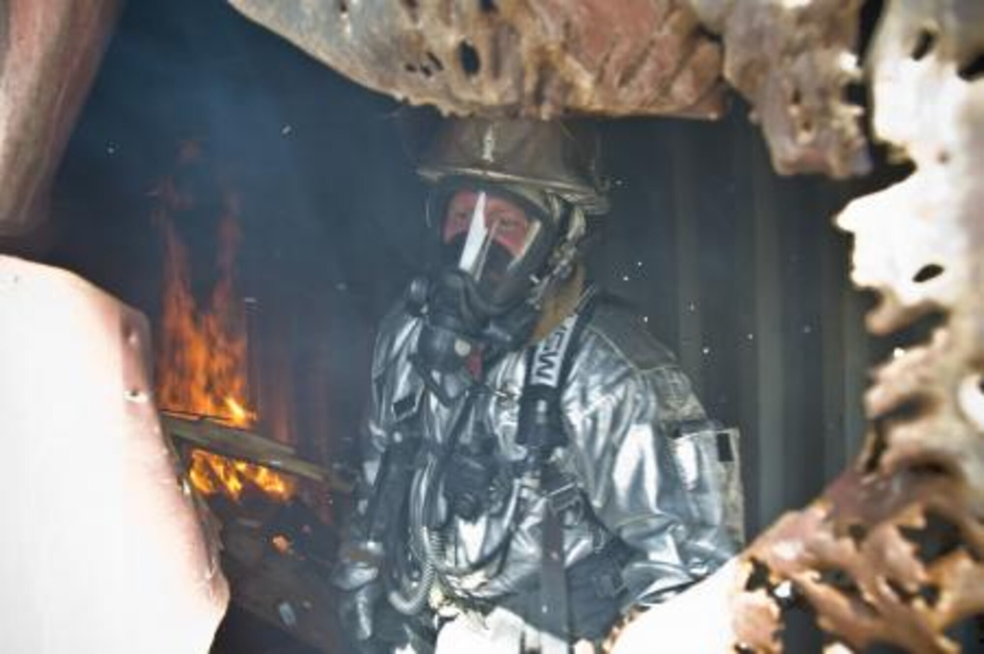 Air Force Master Sgt. Jason Berry, 738th Air Expeditionary Advisory Group fire protection advisor, looks out of a burning, portable, storage container, during the Kandahar Air Wing Afghan firefighters’ first live-burn training exercise at Kandahar Airfield, Afghanistan, March 11. The Verona, Wis., native is an individual augmentee deployed from the 48th Fighter Wing, Royal Air Force Lakenheath, England. (Photo by Senior Airman Jessica Lockoski)


