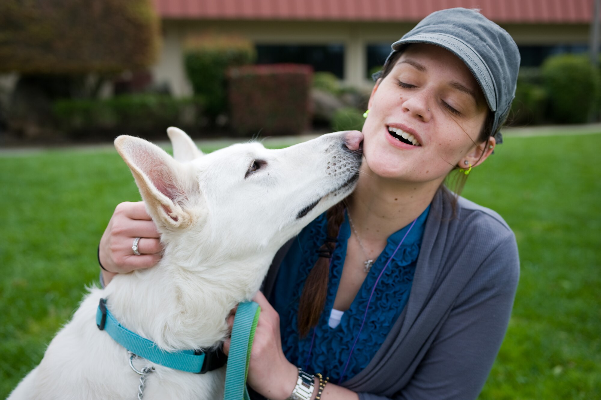 Melissa Jenkins receives a loving kiss from her White German Shepherd, Kasey, on the lawn of the Travis Air Force Base air terminal in California on March 25.
Following the earthquake and tsunami that hit Japan on March 11, Jenkins and hundreds of family members from Misawa Air Base, Japan, voluntarily relocated to the United States after radiation from crippled Japanese nuclear energy plants was detected in some areas. ( U.S. Air Force photo/Ken Wright)
