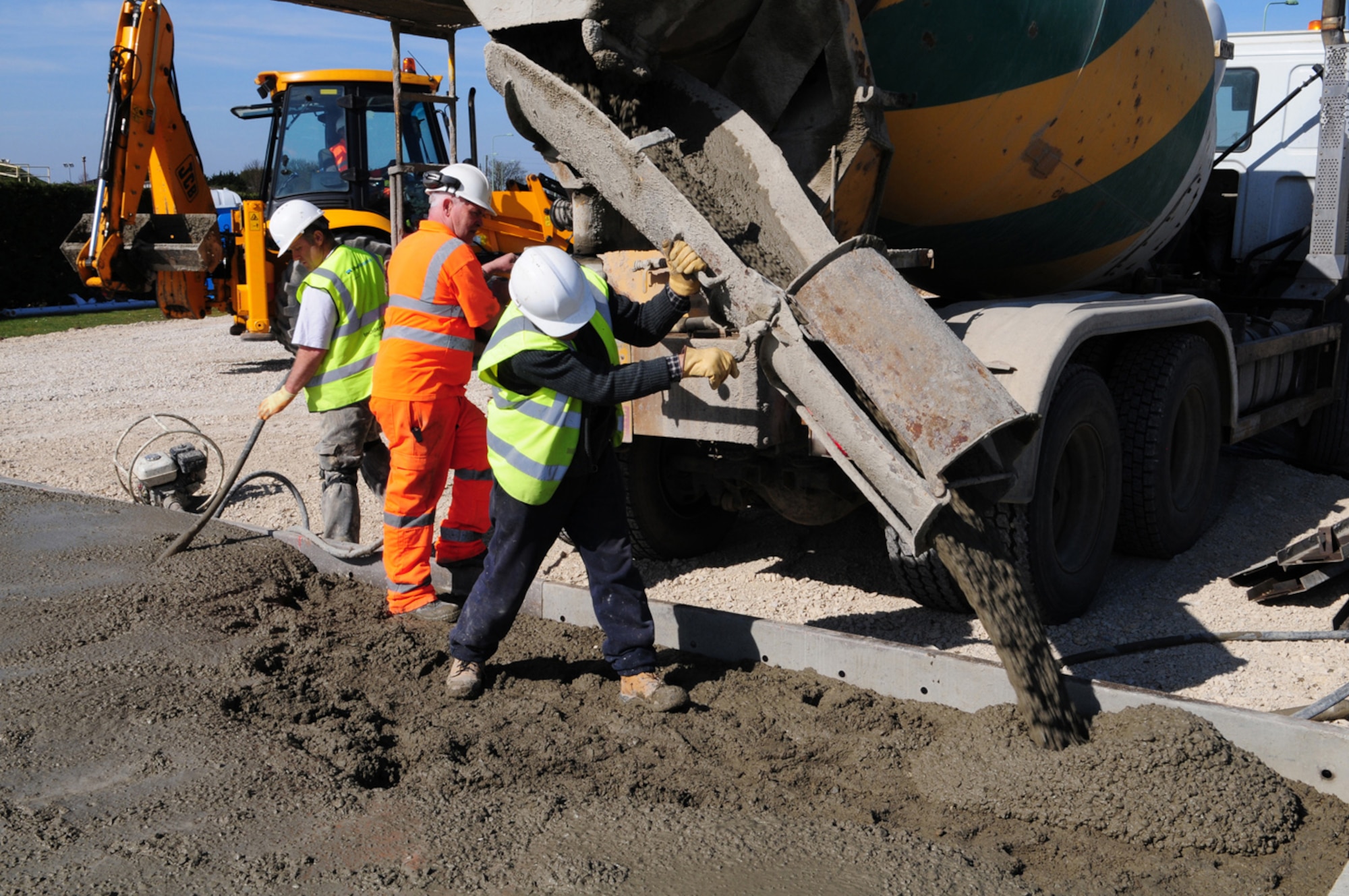 RAF MILDENHALL, England -- Contractors pour wet concrete into a base which will form a pad for a new concrete batching plant here March 24, 2011. The plant now homes large items of equipment to mix concrete, enabling it to be mixed on site, rather than at an off-base location then be brought to RAF Mildenhall by truck. This will reduce the carbon footprint and will save a lot of time when redoing the hardstands later this year. (U.S. Air Force photo/Karen Abeyasekere)