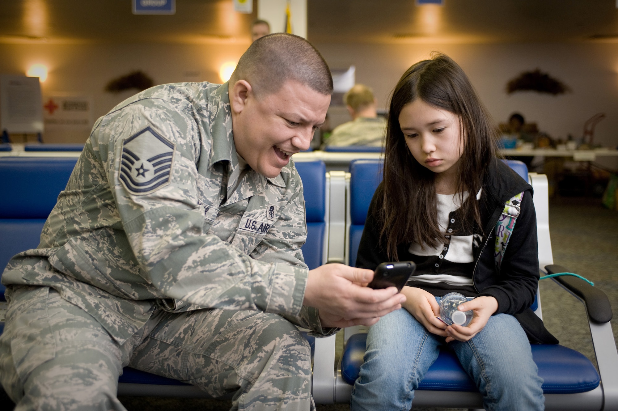 Master Sgt. Brian Leclair tries to cheer up Ariana Payne March 28, 2011, at Travis Air Force Base, Calif. Payne and her mother arrived here following the March 11 natural disasters in Japan. In support of Operation Pacific Passage, Travis AFB members assisted more than 2,600 military dependents as they voluntarily relocated to the U.S. Leclair is assigned to the 60th Air Mobility Wing's Inspector General's Office. (U.S. Air Force photo/Ken Wright)