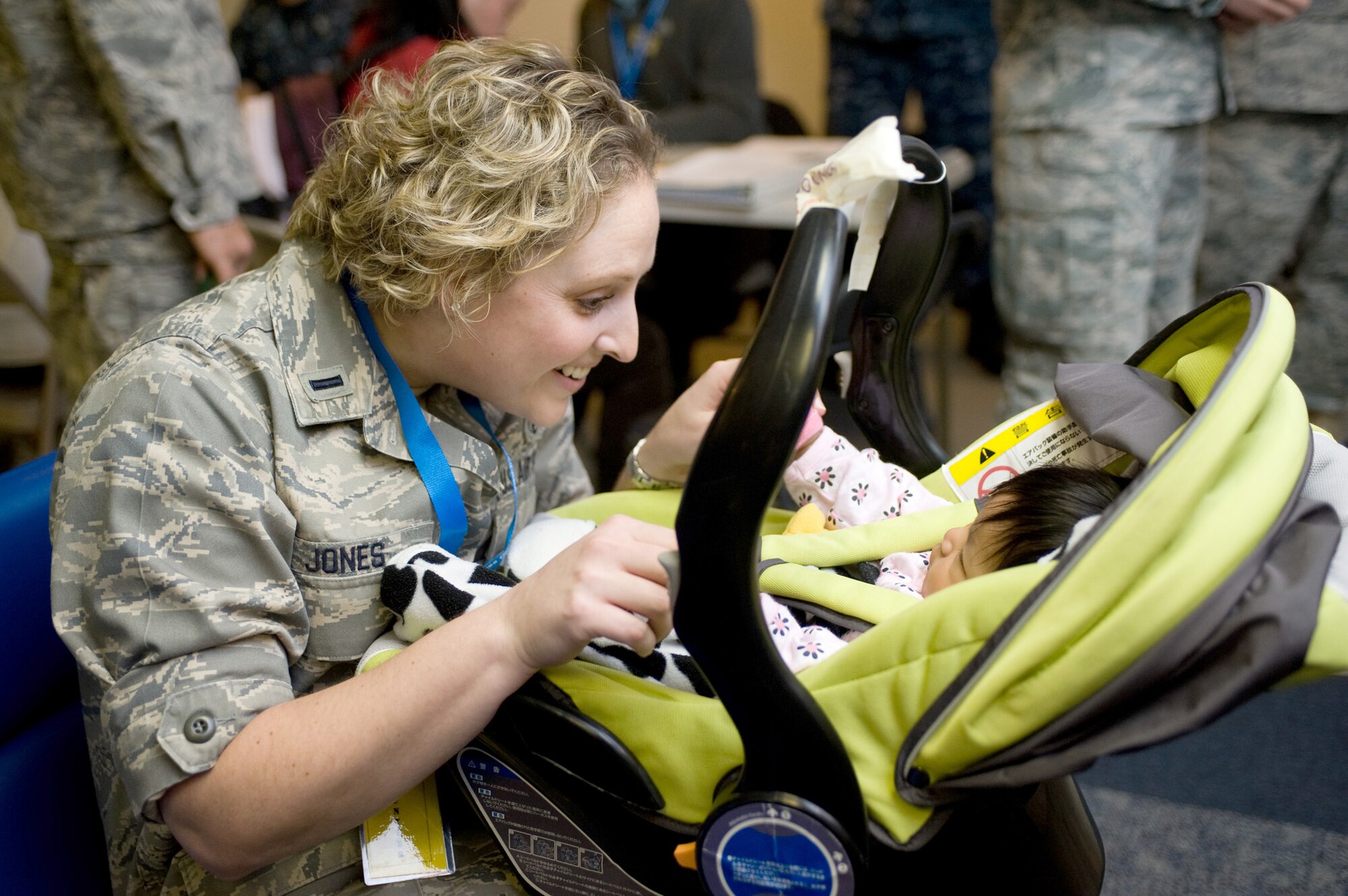 First Lt. Fawn Jones plays with a baby March 28, 2011, at Travis Air Force Base, Calif. The child and her mother arrived here following the March 11 natural disasters in Japan. In support of Operation Pacific Passage, Travis AFB members assisted more than 2,600 military dependents as they voluntarily relocated to the U.S. Jones is a social worker assigned to the 60th Medical Group. (U.S. Air Force photo/Ken Wright) 