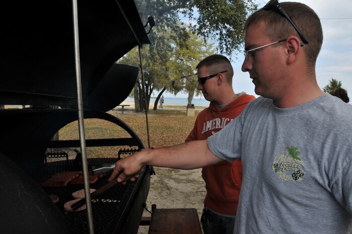 Staff Sgt. Jacob Lurvey (right) and Senior Airman Amos Hommel flip burgers and cook hot dogs during the 2011 Joint Base Charleston Motorcycle Safety Event, March 25 at Short Stay, the Navy?s outdoor recreation facility. Motorcycle riders were given the opportunity to join the Green Knights, a military motorcycle club that provides mentorship to new riders. Sergeant Lurvey and Airman Hommel are from the 628th Communications Squadron. (U.S. Air Force photo/Airman 1st Class Jared Trimarchi)