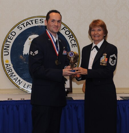 Staff Sgt. (select) Robert Strecker receives the Distinguished Graduate Award from Senior Master Sgt. Linda Sturgeon at the Airman Leadership School graduation March 24, 2011 on Joint Base Charleston, S.C. Sergeant Strecker also received the Leadership award. ALS is a six-week course designed to develop Airmen into effective leaders and supervisors. Sergeant Strecker is an instructor loadmaster attached to the 14th Airlift Squadron and Senior Master Sergeant Strurgeon is assigned to the 315th Airlift Wing education and training office.  (U.S. Air Force photo/Senior Airman Timothy Taylor)