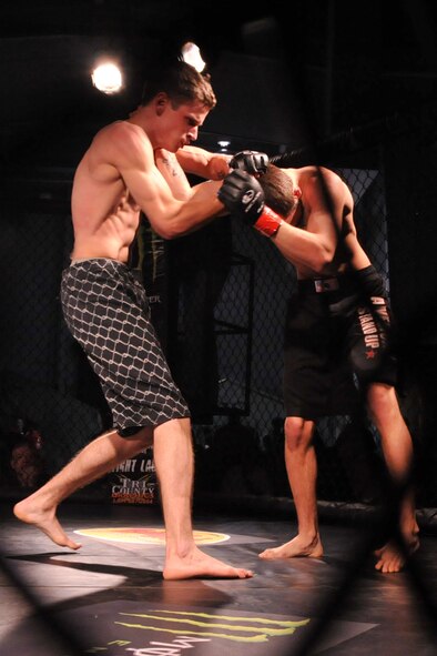 SEYMOUR JOHNSON AIR FORCE BASE, N.C. -- Tyler Brogden hits Joshua Claudio during a mixed martial arts cage fight here, March 25, 2011. Brogden won his first amateur fight by TKO. (U.S. Air Force photo/Senior Airman Whitney Lambert) (RELEASED)