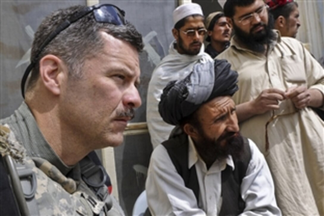 U.S. Army Capt. Michael Butler and Mohammad Aziz meet with the teachers of Abu Herera School in the Urgan district of Afghanistan's Paktika province, March 27, 2011. Butler delivered backpacks and school supplies to Aziz for the students. Both boys and girls attend grades 1-6. Butler is the Paktika Provincial Reconstruction Team Urgun civil affairs team chief and Aziz is the Urgan district's deputy director of education.