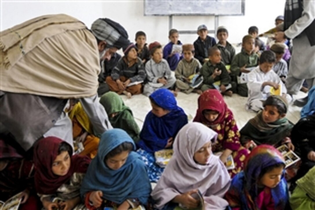 Teachers at Abu Herera School pass out rule of law comic books to first graders in the Urgan district of Afghanistan's Paktika province, March 27, 2011. Paktika Provincial Reconstruction Team members, which include U.S. forces, delivered the books and met with students and teachers on their first day at school following the winter break. 