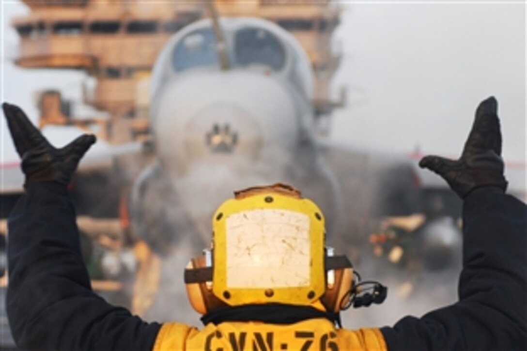 U.S. Navy Seaman Ryan Hilliard directs an EA-6B Prowler on to catapult one before launching off the flight deck of the aircraft carrier USS Ronald Reagan in the Pacific Ocean, March 29, 2011. The Ronald Reagan is off the coastline of Japan providing disaster relief and humanitarian assistance to Japan to support Operation Tomodachi. Hilliard is an aviation boatswain's mate and the Prowler is assigned to the Tactical Electronic Warfare Squadron 139.