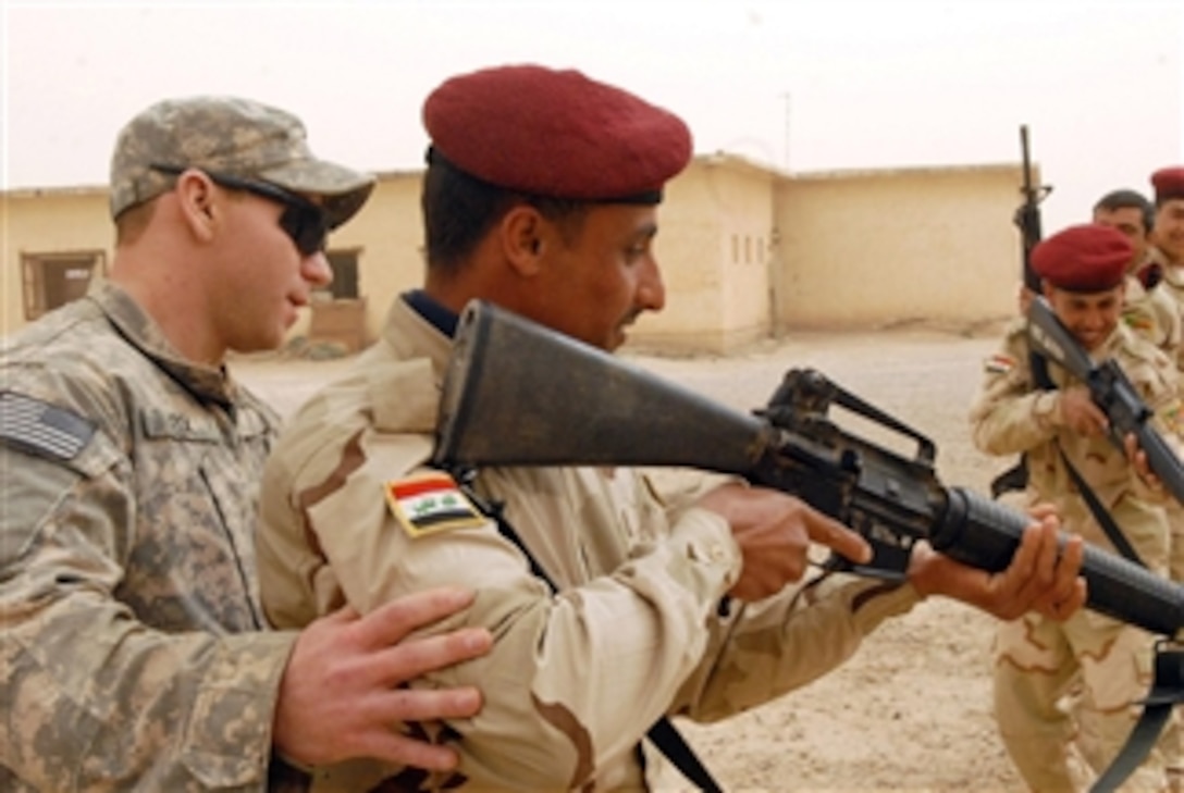 U.S. Army Sgt. Ryan Fox (left), with Bravo Company, 3rd Battalion, 15th Infantry Regiment, 4th Advise and Assist Brigade, 3rd Infantry Division, assists Iraqi army soldiers assigned to 8th Iraqi army Brigade, 1st Division, as the soldiers practice Military Operations in Urban Terrain procedures at Camp Taqaddum, Iraq, on March 8, 2011.  