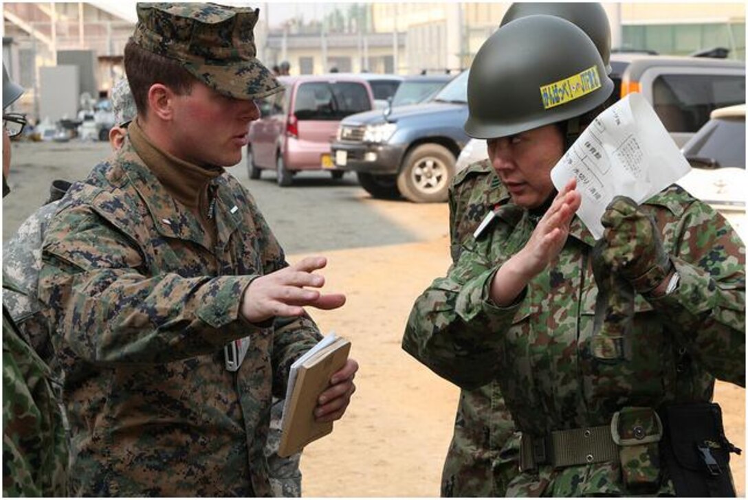 1st Lt. Sean McMahon coordinates plans with a Japan Self-Defense Force member before U.S. service members begin cleaning the Ishinomaki High School at Operation Field Day.