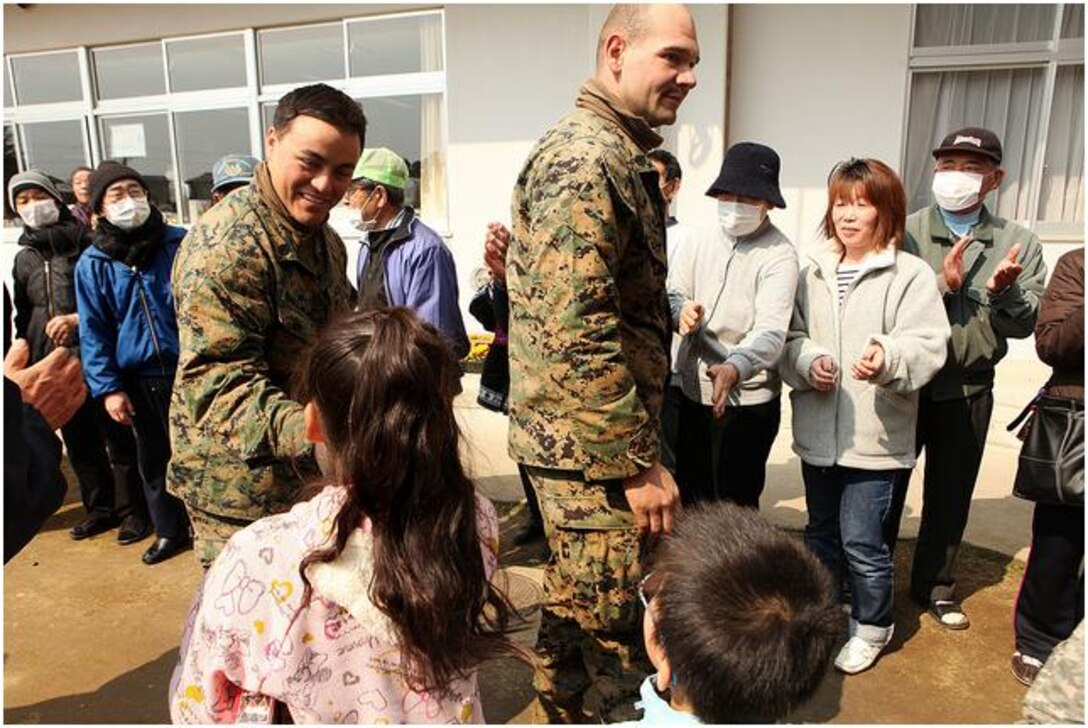 Staff Sgt. Jaime Barajasmora (left) and Sgt. Christopher Oliveri (right) shake hands with Japanese civilians during Operation Tomodachi.