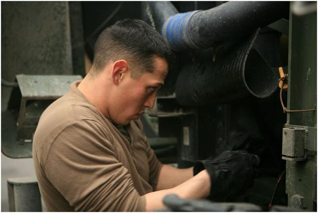Cpl. Tadehara, a heavy equipment mechanic fixes a seven-ton truck. The truck was part of a convoy supplying kerosene for heating to areas of Japan hardest hit by the March 11 earthquake and tsunami.
