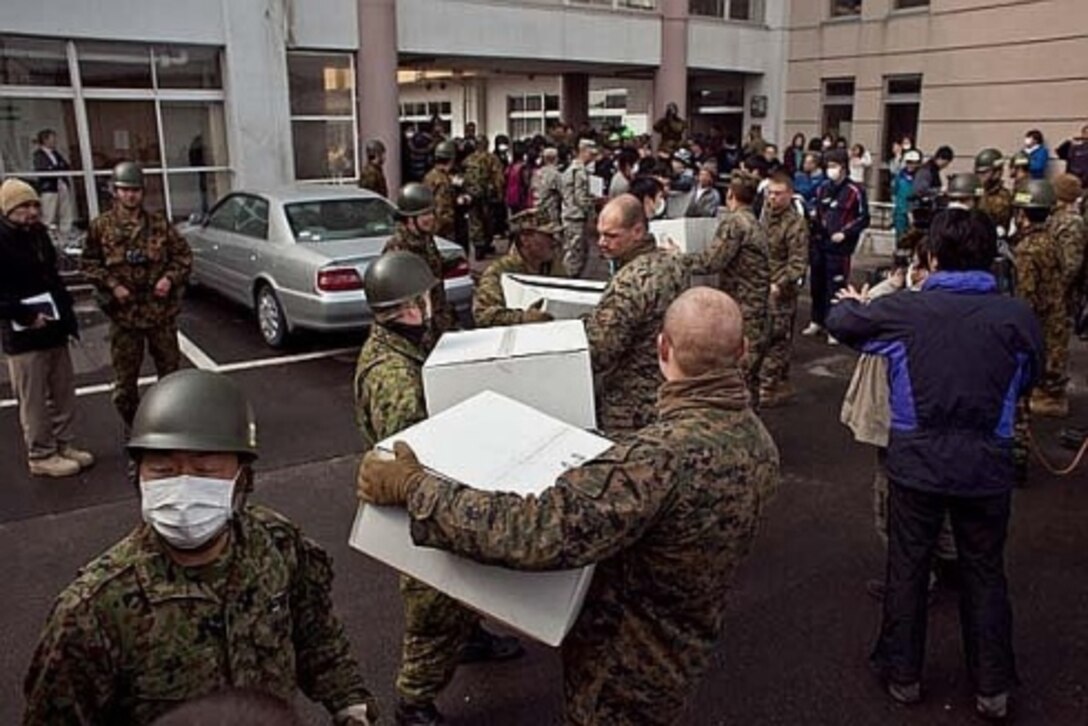 Camp Fuji Marines working alongside the Japanese Ground Self Defense Force to distribute hygiene supplies to Watari city.
