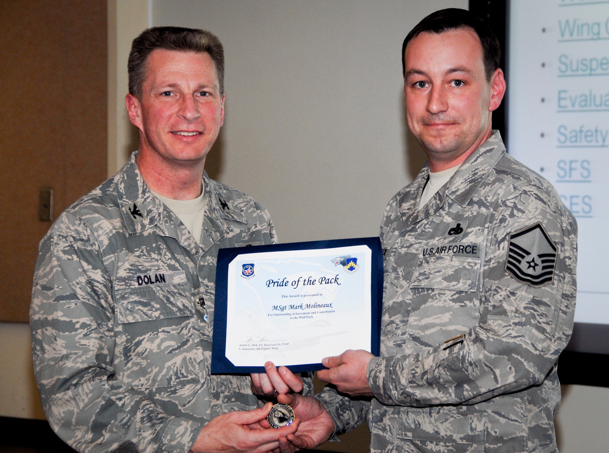 KUNSAN AIR BASE, Republic of Korea -- Col. John Dolan, 8th Fighter Wing commander, presents Master Sgt. Mark Molineaux, 8th Maintenance Squadron phase inspection section NCO in charge, with a Pride of the Pack award here March 31. (U.S. Air Force photo/Capt. Sheryll Klinkel)
