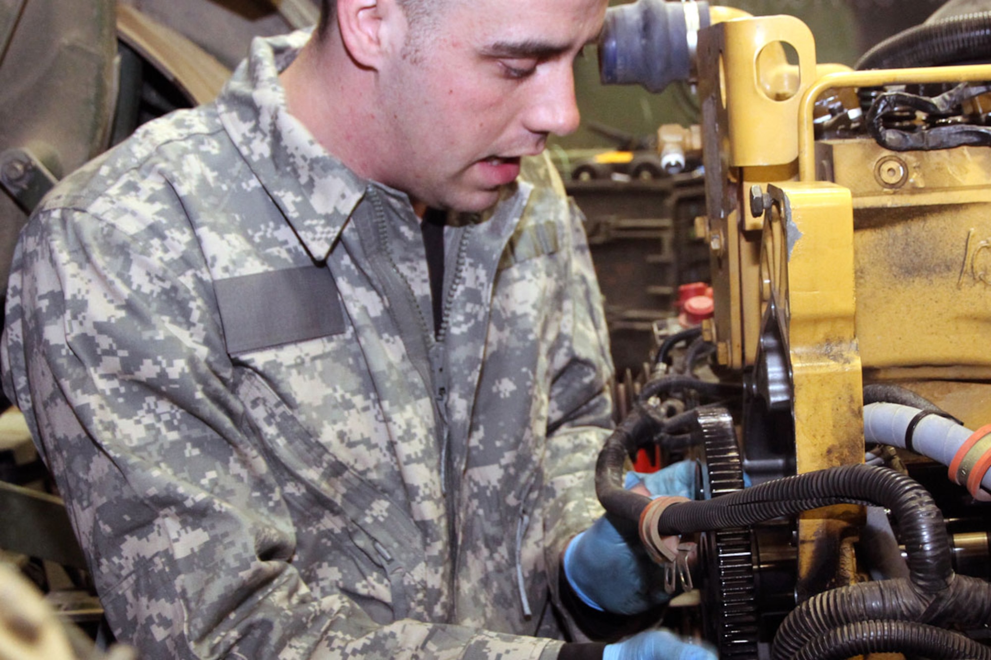 Spc. James D. Johnson, a wheeled vehicle repairer with Forward Support Company, 6th Engineer Battalion (Airborne), pulls a crank shaft March 17 at the battalion motor pool. (U.S. Army photo/Sgt. Tamika Dillard)