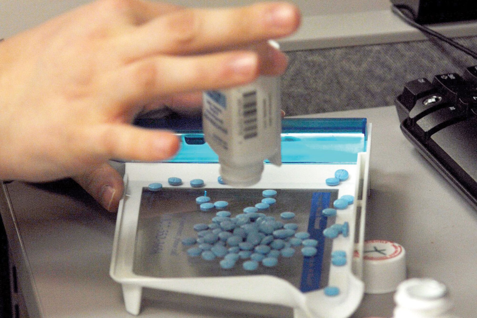 A member of the 673d Medical Group Pharmacy pours medication onto a counting
block, March 24. (U.S. Air Force photo/A1C Jack Sanders)