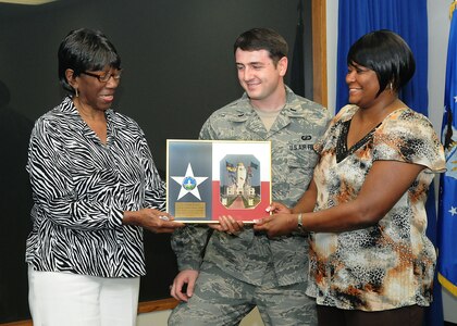 Randolph AFB, TX, 3/31/2011:  Lucille Bridges, left, mother of Ruby Bridges who was among the first African-Americans to integrate New Orleans public schools in 1960, accepts a photo of the "Taj" over the Texas flag, after a Women's History Month lecture at Randolph Air Force Base, Texas on March 31, 2011. Presenting the gift are 1st Lt. William Waterworth, chairman of Women's History Month committee, and Precious Wallace, with Headquarter's Air Education and Training Command/ Civil Engineering at the base. (U.S. Air Force photo/David Terry)