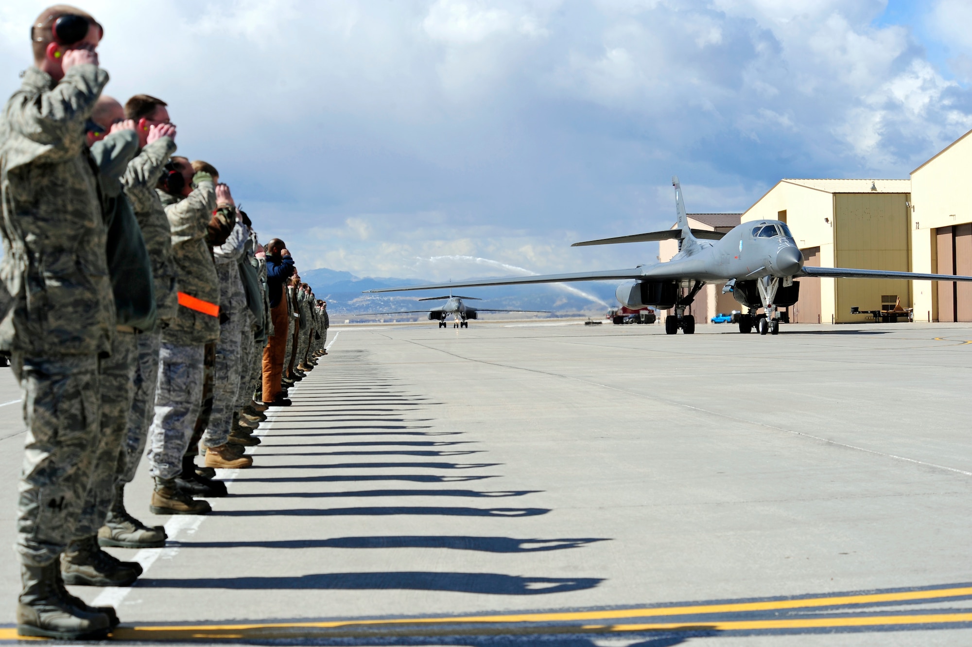 Airmen from the 28th Bomb Wing salute two returning B-1B Lancers as they taxi to their parking area on Ellsworth Air Force Base, S.D., March 30, 2011.  The B-1s bombed targets in Libya in support of Operation Odyssey Dawn. (U.S. Air Force photo/Staff Sgt. Marc I. Lane)