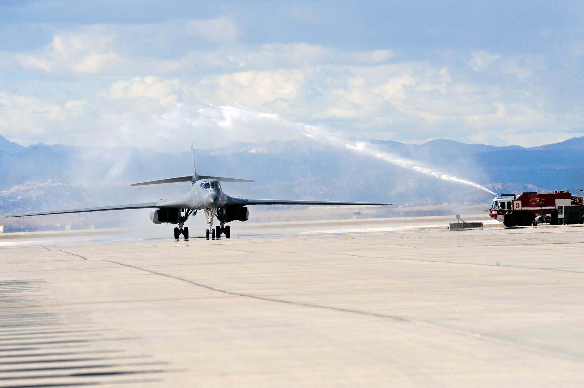 A fire truck from the 28th Civil Engineer Squadron fire department heralds the return of a B-1B returning from striking targets in Libya in support of Operation Odyssey Dawn, March 30, 2011.   This mission from Ellsworth Air Force Base, S.D. marked the first time the B-1 fleet has launched combat sorties from the continental United States to strike targets overseas. (U.S. Air Force photo/Staff Sgt. Marc I. Lane)