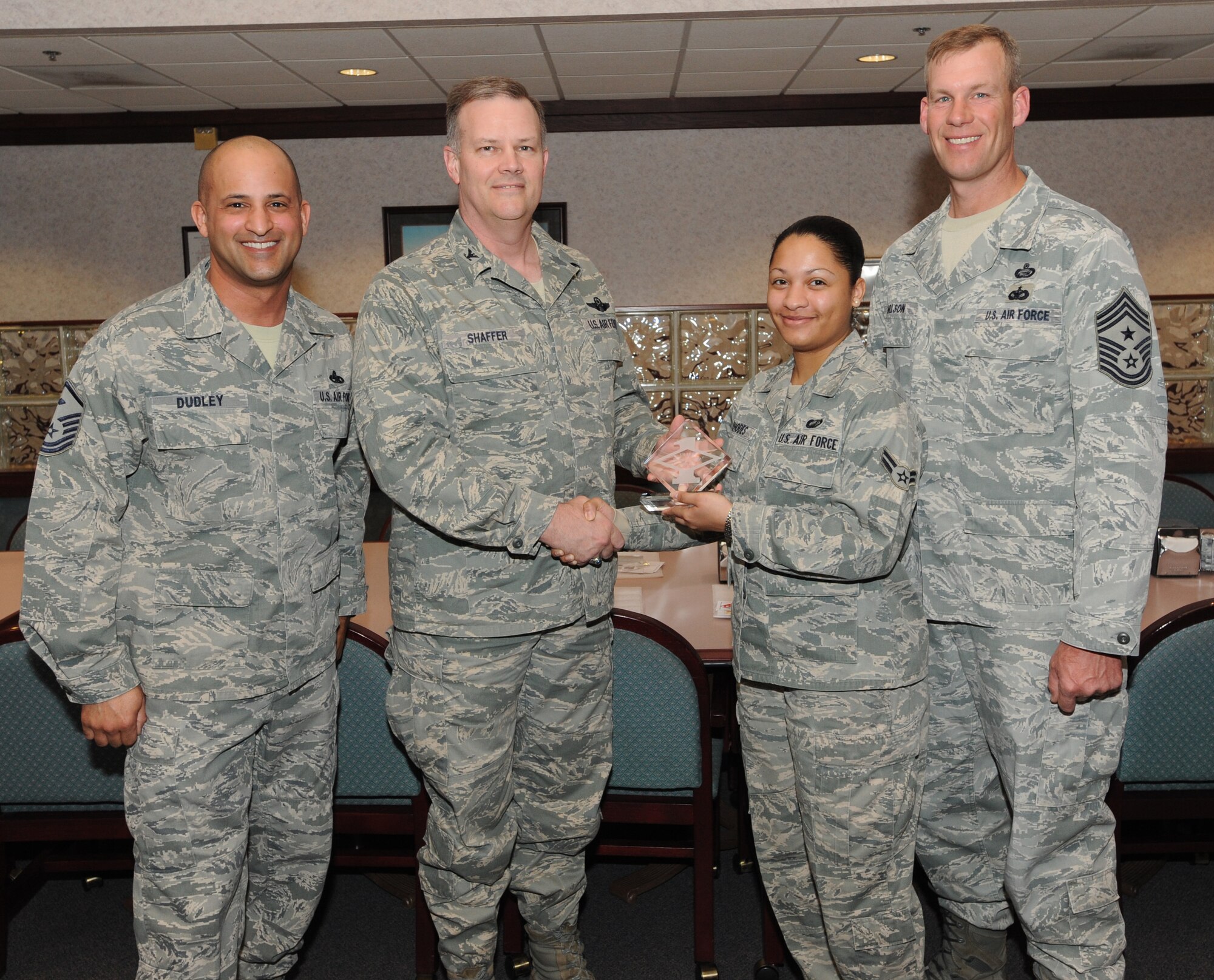 Col. Don Shaffer, 319th Air Base Wing commander, presents Airman 1st Class Teresa Rhodes, 319th Comptroller Squadron, with a Diamond Sharp Award Mar. 31 at Airey Dining Facility here, accompanied by Command Chief Master Sgt. David Carlson, 319th Air Base Wing, and Master Sgt. Luca Dudley, 319th Comptroller Squadron first sergeant. The Diamond Sharp Award is given to those Airmen who epitomize service before self and strive for excellence at work and off duty. (U.S. Air Force photo by Staff Sgt. Suellyn Nuckolls)