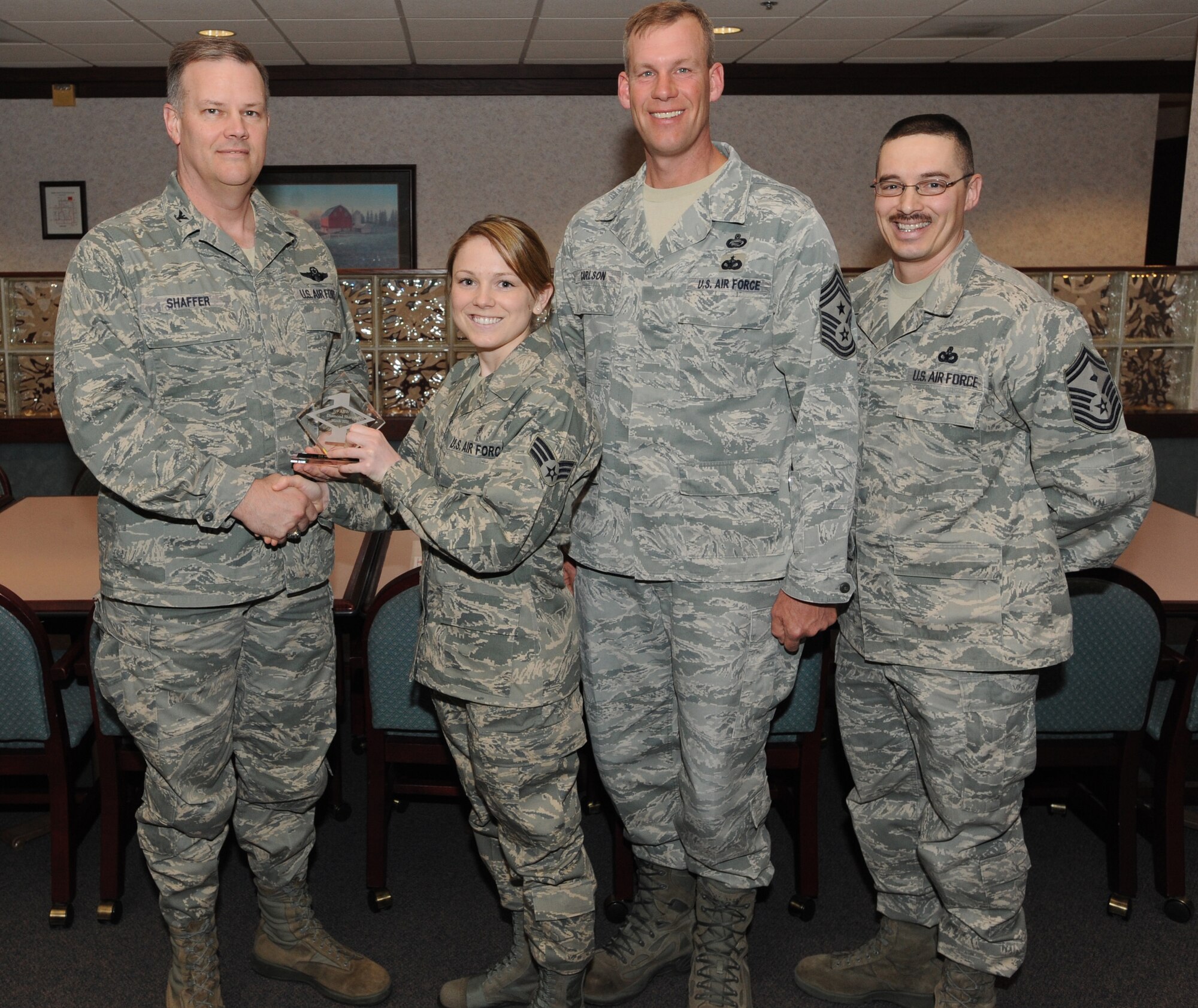 Col. Don Shaffer, 319th Air Base Wing commander, presents Senior Airman Shay Wood, 319th Medical Operations Squadron, with a Diamond Sharp Award Mar. 31 at Airey Dining Facility here, accompanied by Command Chief Master Sgt. David Carlson, 319th Air Base Wing, and Senior Master Sgt. Keith Waltz, 319th Medical Group/Communications Squadron first sergeant. The Diamond Sharp Award is given to those Airmen who epitomize service before self and strive for excellence at work and off duty. (U.S. Air Force photo by Staff Sgt. Suellyn Nuckolls)