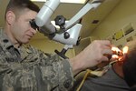 U.S. Air Force Lt. Col. (Dr.) Mark Packer performs operative care and inspection on U.S. Army Specialist James Tillery at Wilford Hall Medical Center's Hearing Center of Excellence March 2, 2011, Lackland Air Force Base, Texas. Working to further the medical science, Dr. Packer is the director of the several Department of Defense-directed Centers of Excellence and is an Otolaryngologist. Specialist Tillery was injured by an improvised explosive device during a tour in Afghanistan. He is being treated for tympano-mastoidectomy with ossicular reconstruction at Wilford Hall and is currently stationed at Fort Polk, LA. (U.S. Air Force photo/Staff Sgt. Robert Barnett)