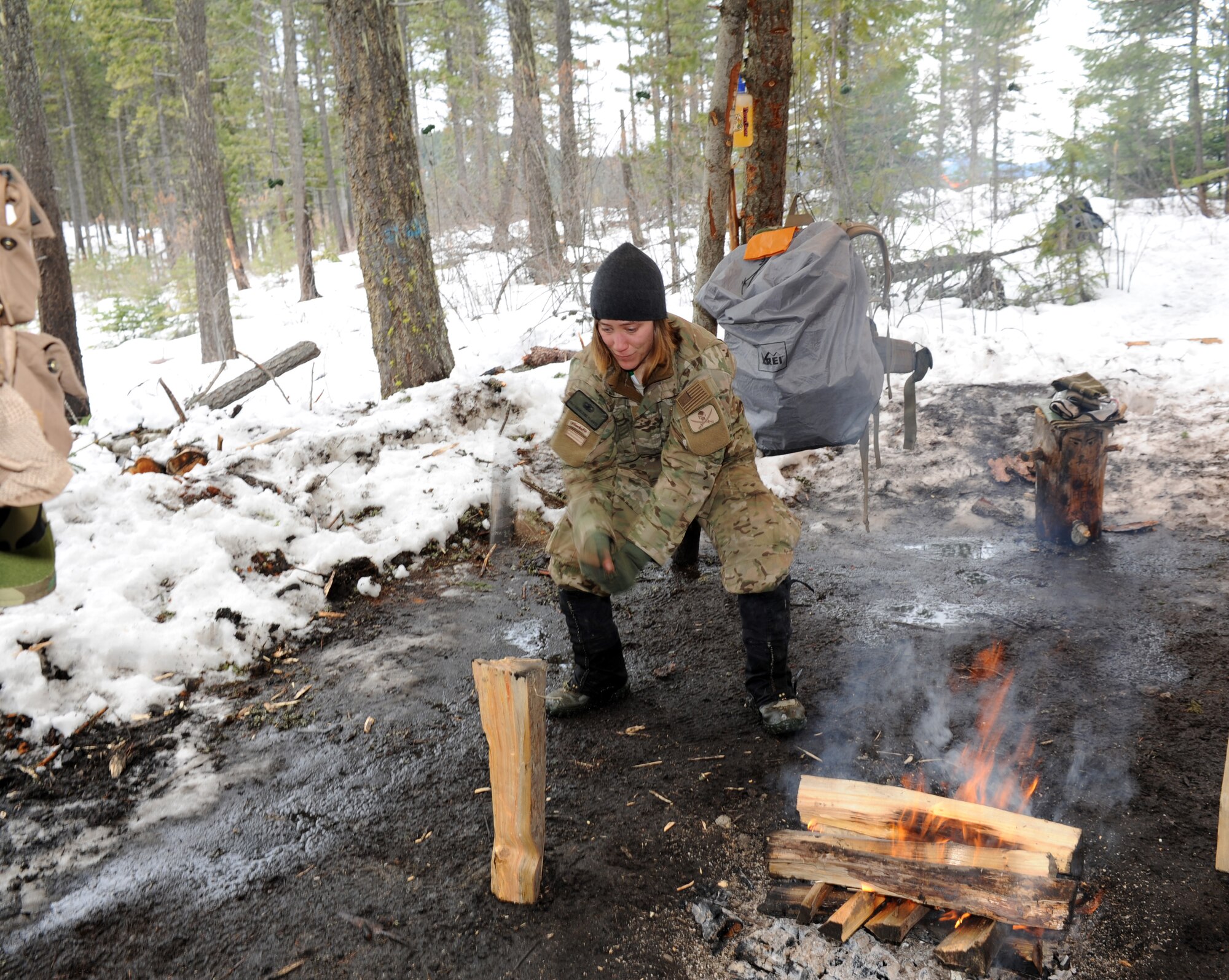 Senior Airman Charlene Plante, 22nd Training Squadron, Survival Evasion Resistance Escape specialist, chops wood for a fire for her students March 13, 2011 in the Colville National Forest, Wash. The fire will ensure her students have the capability of drying their wet cloths and provide much needed warmth. Airman Plante will use this time to check her students for frostbite as a safety precaution. (U.S. Air Force Photo/Tech. Sgt. JT May III)