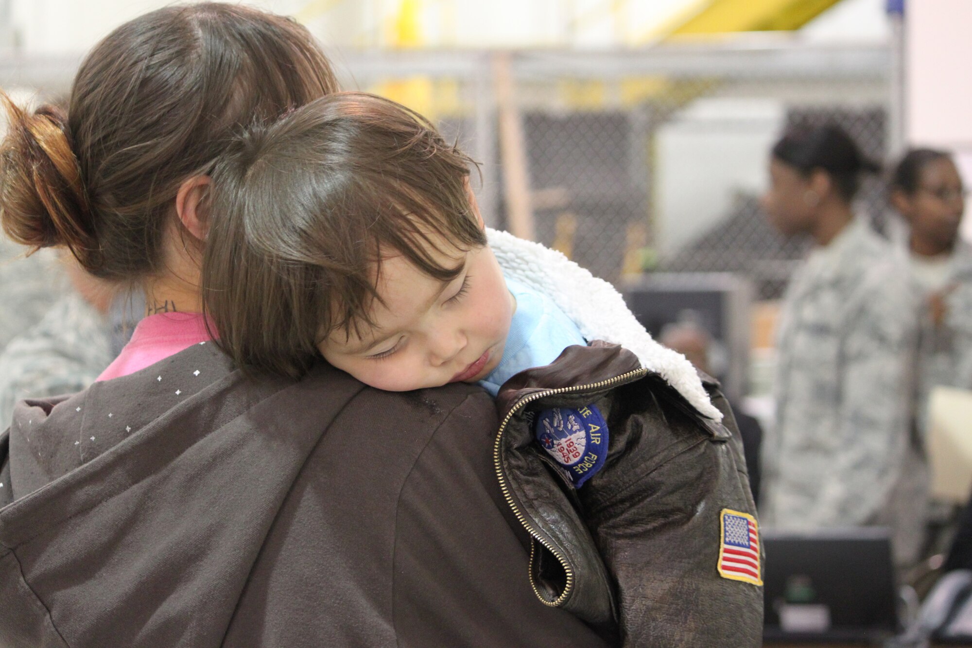 After a day of flying, 2-year-old Aiden sleeps on mother Judy Britting's shoulders March 24 at Denver International Airport. They were among of the 240 passengers who processed and passed through DIA, March 24, to stay with immediate family members or close friends in the United States. Passengers coming through  DIA  for Operation Pacific Passage, are eligible dependents of U.S. service members and non-emergency DoD civilians stationed in Japan who have voluntarily departed after the earthquake, tsunami and ongoing nuclear emergency. (U.S. Air Force Photo/Staff Sgt. Desiree Economides)

