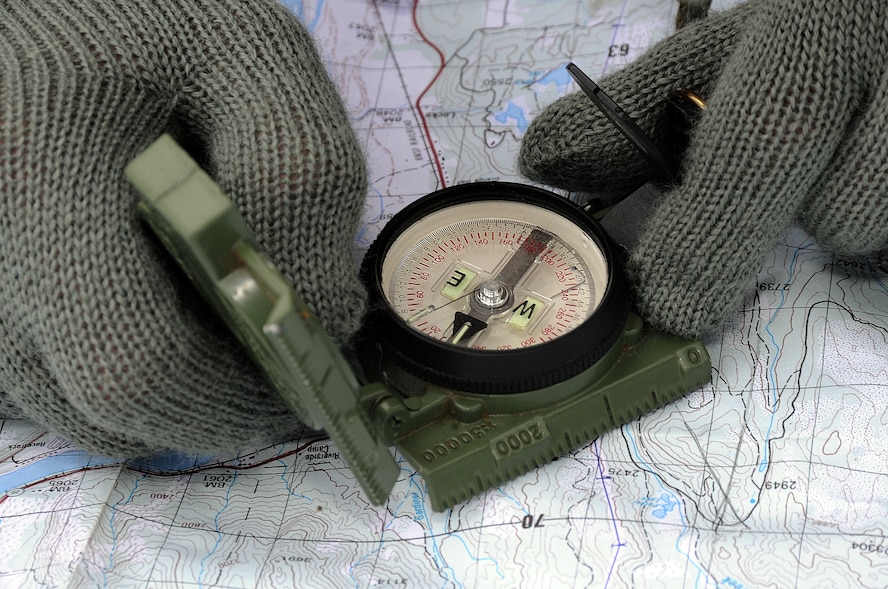 A student uses a map and compass March 13, 2011, during survival, evasion, resistance and escape training in Colville National Forest, Wash. During the land navigation phase of SERE training, a student is able to isolate to a five mile radius on a map where he or she is located. (U.S. Air Force photo/Tech. Sgt. J.T. May III)