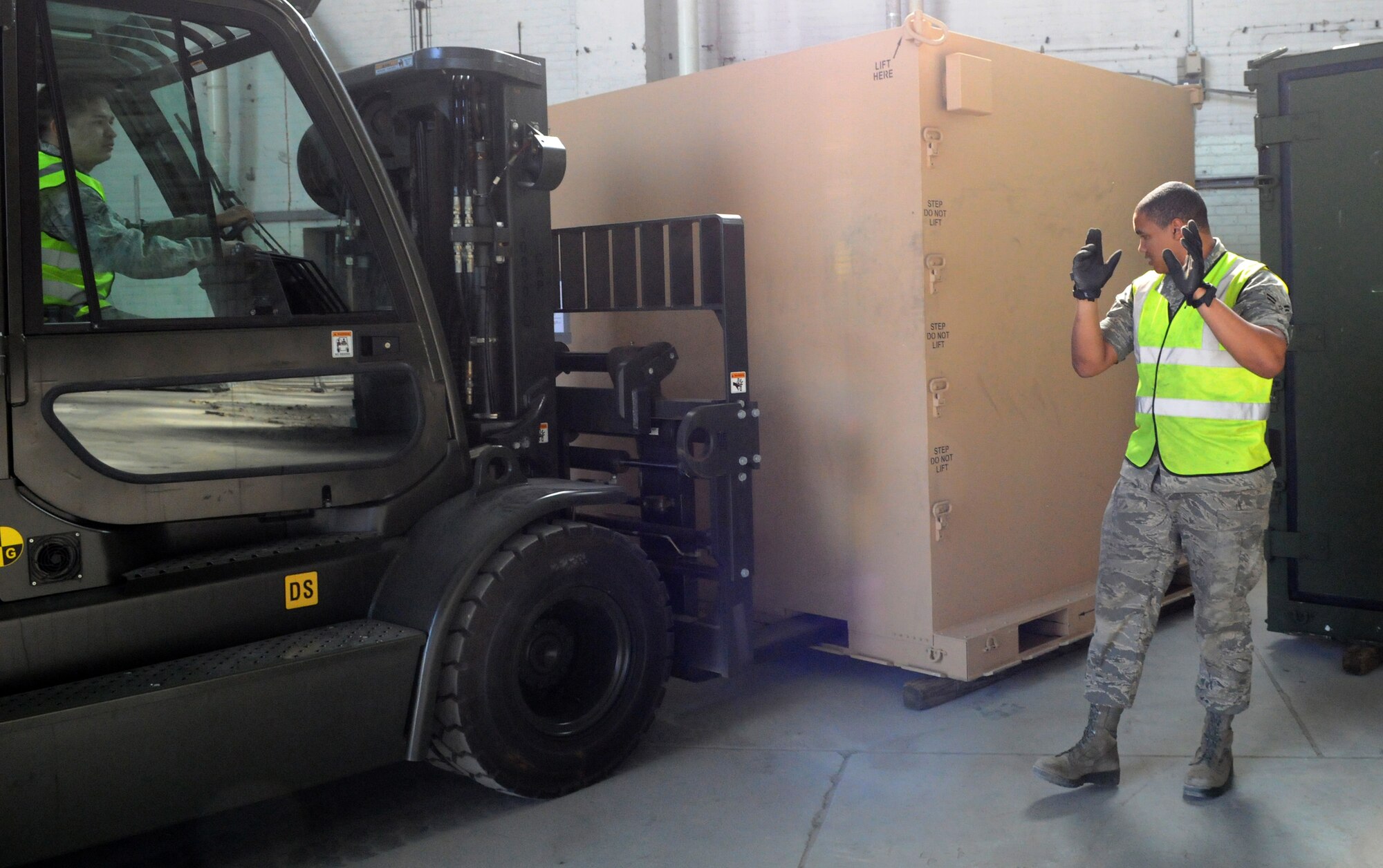 An Airman from the 100th Logistics Readiness Squadron cargo deployment function marshals a forklift operator away from a pallet here March 23. The pallet will be sent via airlift to support Joint Task Force Odyssey Dawn.  JTF Odyssey Dawn is the U.S. Africa Command task force established to provide operational and tactical command and control of U.S. military forces supporting the international response to the unrest in Libya and enforcement of United Nations Security Council Resolution (UNSCR) 1973. UNSCR 1973 authorizes "all necessary measures" to protect civilians in Libya under threat of attack by Gadhafi regime forces. JTF Odyssey Dawn is commanded by U.S. Navy Admiral Sam Locklear. (U.S. Air Force photo by Airman 1st Class Rachel Waller/Released)