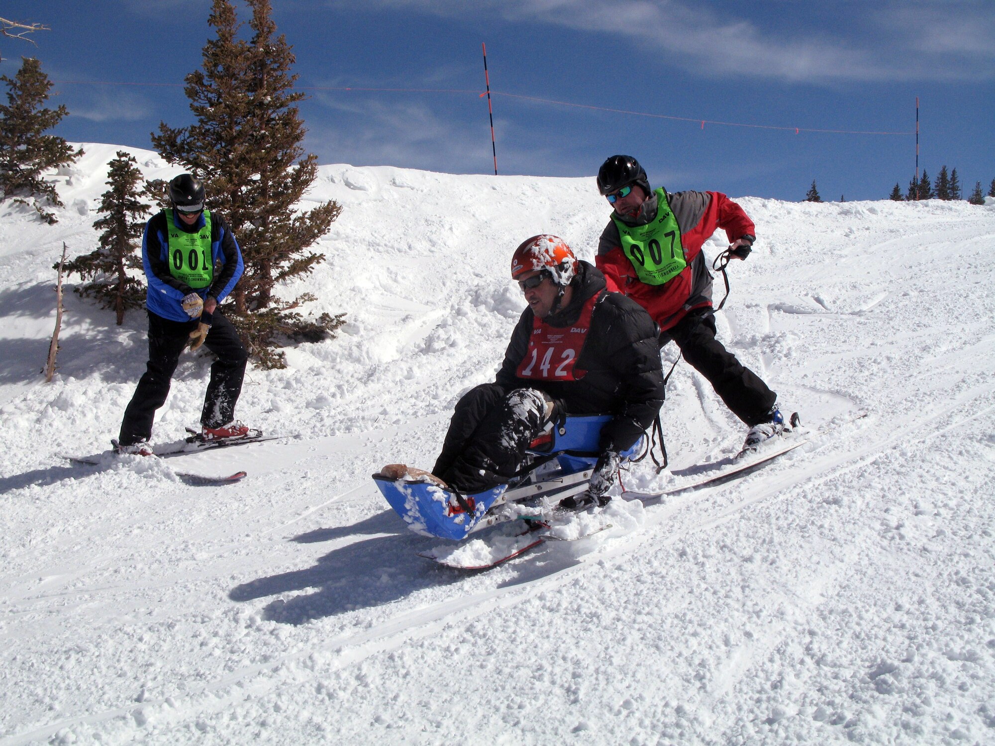 Volunteer instructors Steve Wanovich and Bryan Wood help Army Spc. Alejandro Calvo as he navigates the deep powder at the top of Colorado's Snowmass Mountain during the 25th National Disabled Veterans Winter Sports Clinic, March 29, 2011. (DOD photo/Donna Miles)