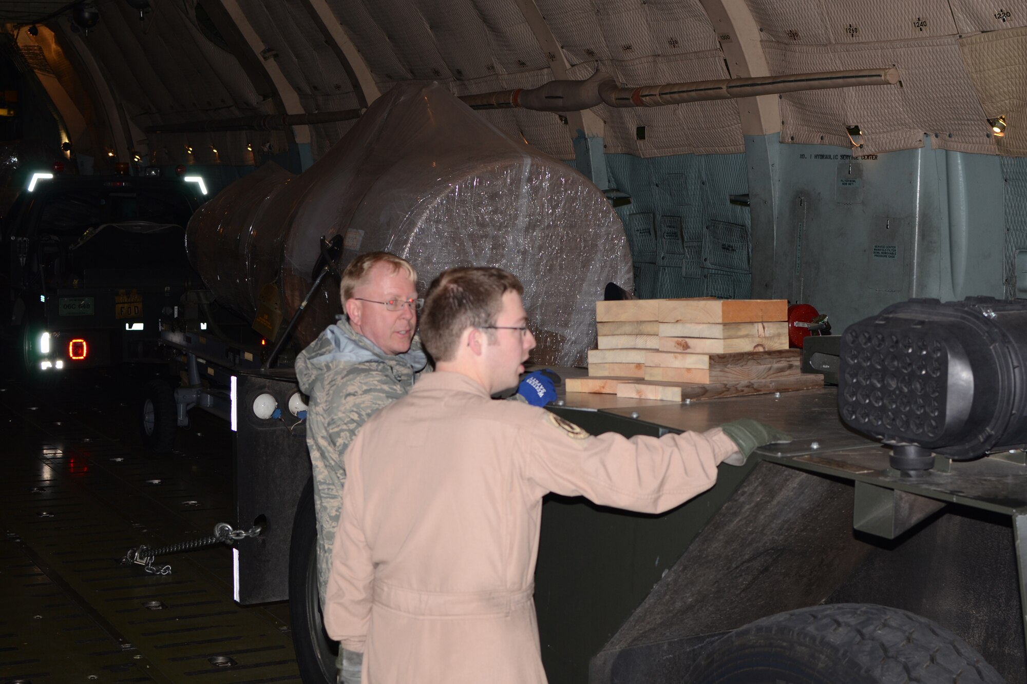 WRIGHT-PATTERSON AIR FORCE BASE, Ohio – Master Sgt. David White and Staff Sgt. Travis Egger, both loadmasters from the 89th Airlift Squadron, load support equipment belonging to the 552nd Air Control Wing, Tinker Air Force Base, Okla., onto a 445th Airlift Wing C-5 Galaxy March 22. The 89th AS loaded the equipment at Tinker and delivered it to Rota Naval Air Station, Spain, in support of Operation Odyssey Dawn. The 445th’s C-5 was one of four C-5s tasked to transport the equipment and ground crew that night. (U.S. Air Force photo/Senior Master Sgt. Michael Kalbfleisch)