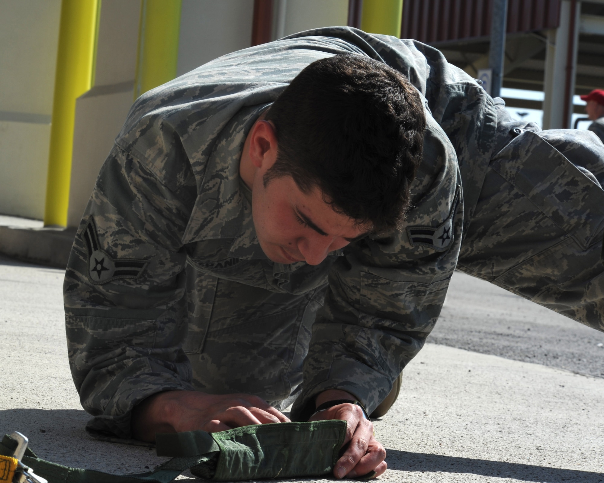 Airman 1st Class Jonathan Sepanik, 8th Air Support Operations Squadron tactical air control party, meticulously folds his hook pile tape lowering line in preparation for his second equipment jump during a joint coalition training exercise March 23. More than 1,400 personnel from the U.S. Army 173rd Airborne Brigade Combat team, the 8th ASOS and Italian army paratroopers participated in the weeklong event.(U.S. Air Force photo/ Staff Sgt. Nadine Y. Barclay)