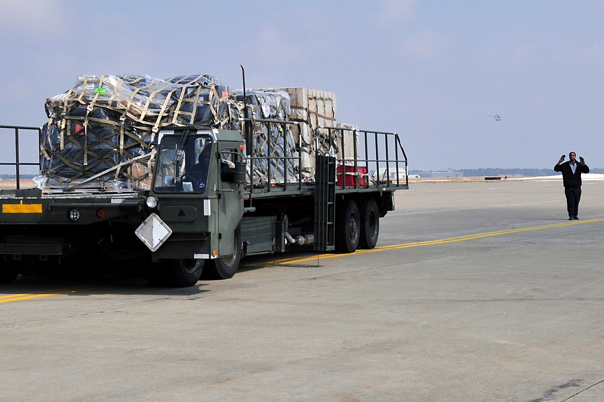 MISAWA AIR BASE, Japan --  Mr. Terrence Hughes, a Maytag employee, marshals out a 40K loader March 31. Nearly one million pounds of cargo has been moved in and out of Misawa AB since Operation Tomodachi began.  (U.S. Air Force photo by Staff Sgt. Marie Brown\Released)