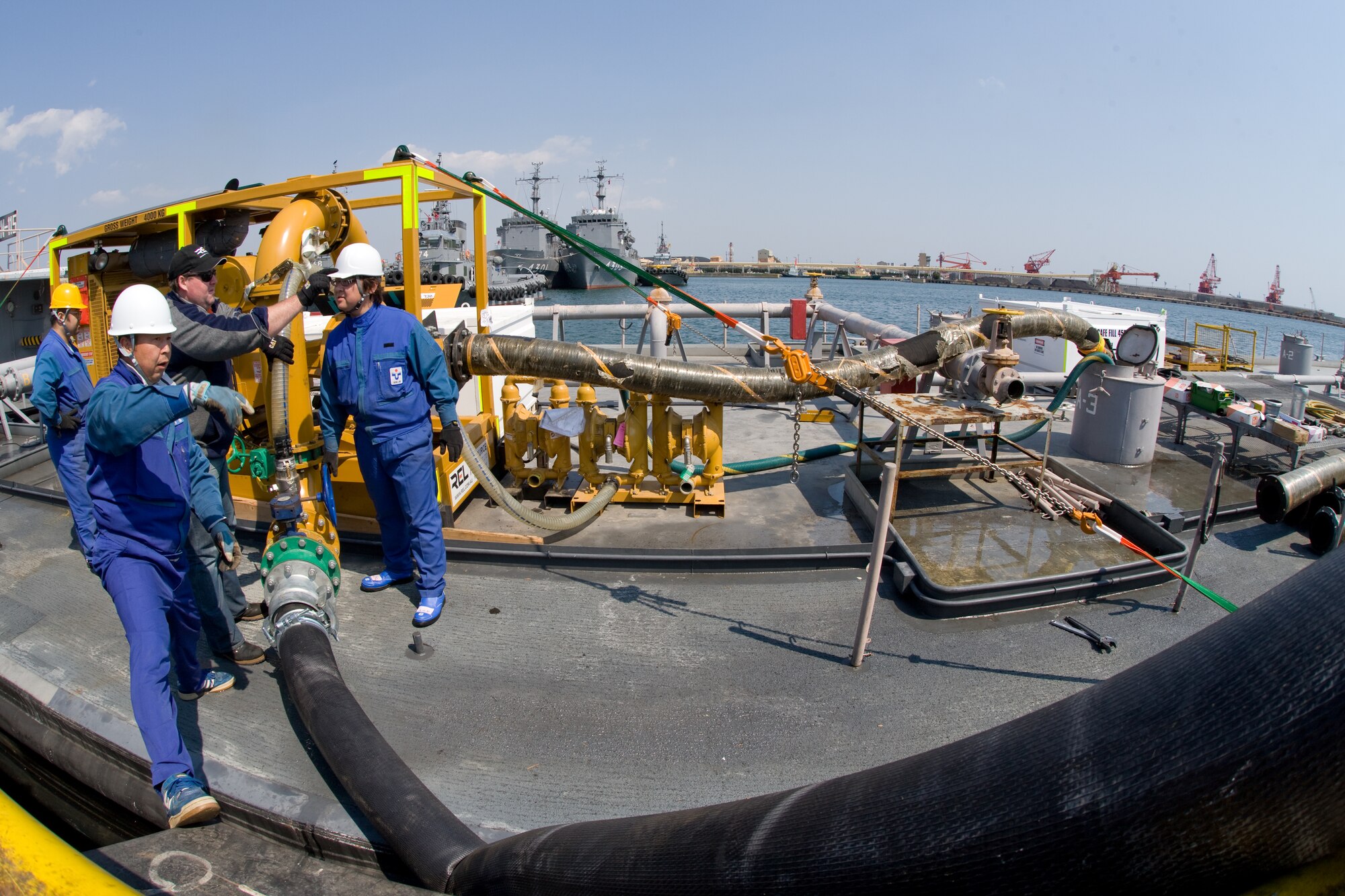 ONAHAMA, Japan -- A bilateral task force from the United States and Australia help Tokyo Electric Power Company employees complete a fresh water cooling system March 29, 2011.  The system of high pressure pumps and hoses will be used to spray freshwater from barges onto the Fukushima nuclear power plant. Japan Maritime Self-Defense Force vessels towed the barges full of freshwater from Yokosuka to the site.  Eight Yokota Airmen designed and created necessary adapters, pressure valves and other pieces of equipment to modify the pumps for the mission. (U.S. Air Force photo/Osakabe Yasuo)