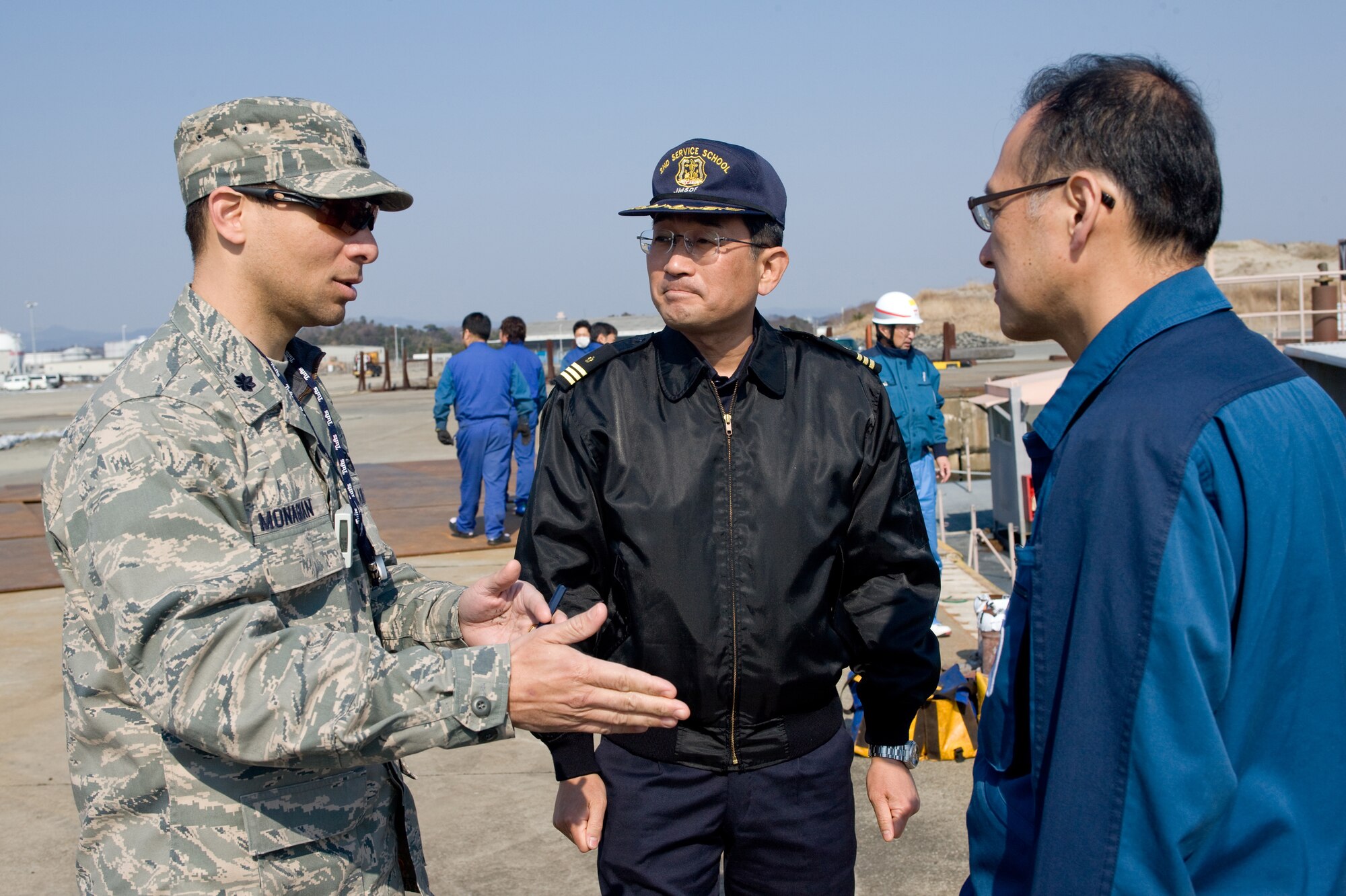 ONAHAMA, Japan -- Lt. Col. Dylan Monaghan, U.S. Embassy Tokyo, coordinates  with officials from the Japan Maritime Self-Defense Force and Tokyo Electric Power Company at Onahama port March 29, 2011. The U.S. government donated a system of high pressure pumps and hoses to be used to spray freshwater from barges onto the Fukushima nuclear power plant. Japan Maritime Self-Defense Force vessels towed the barges full of freshwater from Yokosuka to the site.  Eight Yokota Airmen designed and created necessary adapters, pressure valves and other pieces of equipment to modify the pumps for the mission. (U.S. Air Force photo/Osakabe Yasuo)
