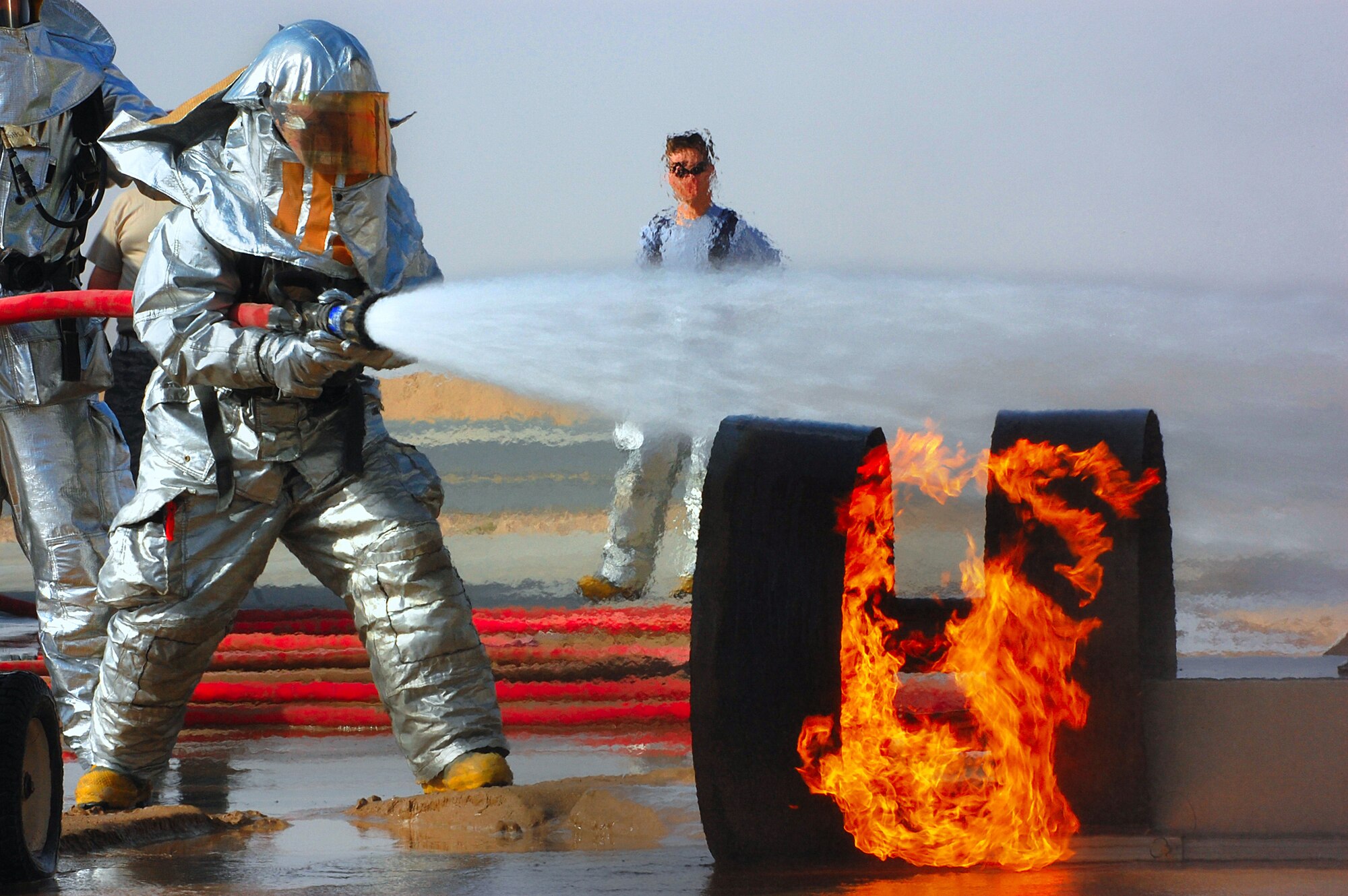 Senior Airman Stephen Peacock uses a handline to extinguish a simulated wheel fire during training in Southwest Asia March 26. A handline has a water pressure of 100 pounds per square inch and loses 5 psi for every 100 feet of hose used. Airman Peacock is a firefighter with the 386th Expeditionary Civil Engineer Squadron (U.S. Air Force photo by Senior Airman Cynthia Spalding)