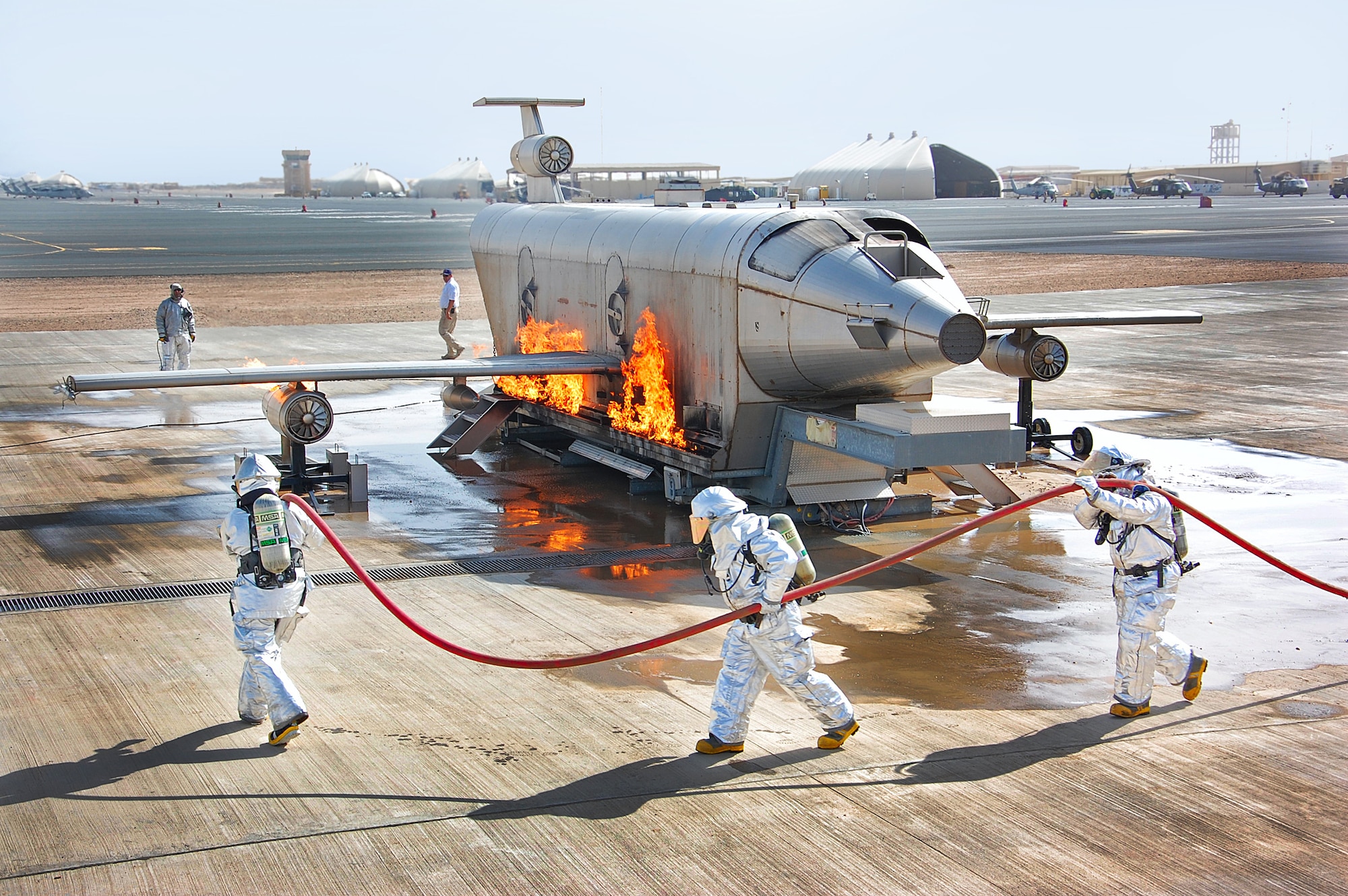 Master Sgt. Ricky Hoffman, Tech. Sgt. Michael Epperson and Senior Airman Buddy Roark advance a hose line before extinguishing a fuselage fire during training in Southwest Asia March 26. In most situations when using a handline a three-man team is standard for a fire attack. The firefighters are with the 386th Expeditionary Civil Engineer Squadron. (U.S. Air Force photo by Senior Airman Cynthia Spalding)