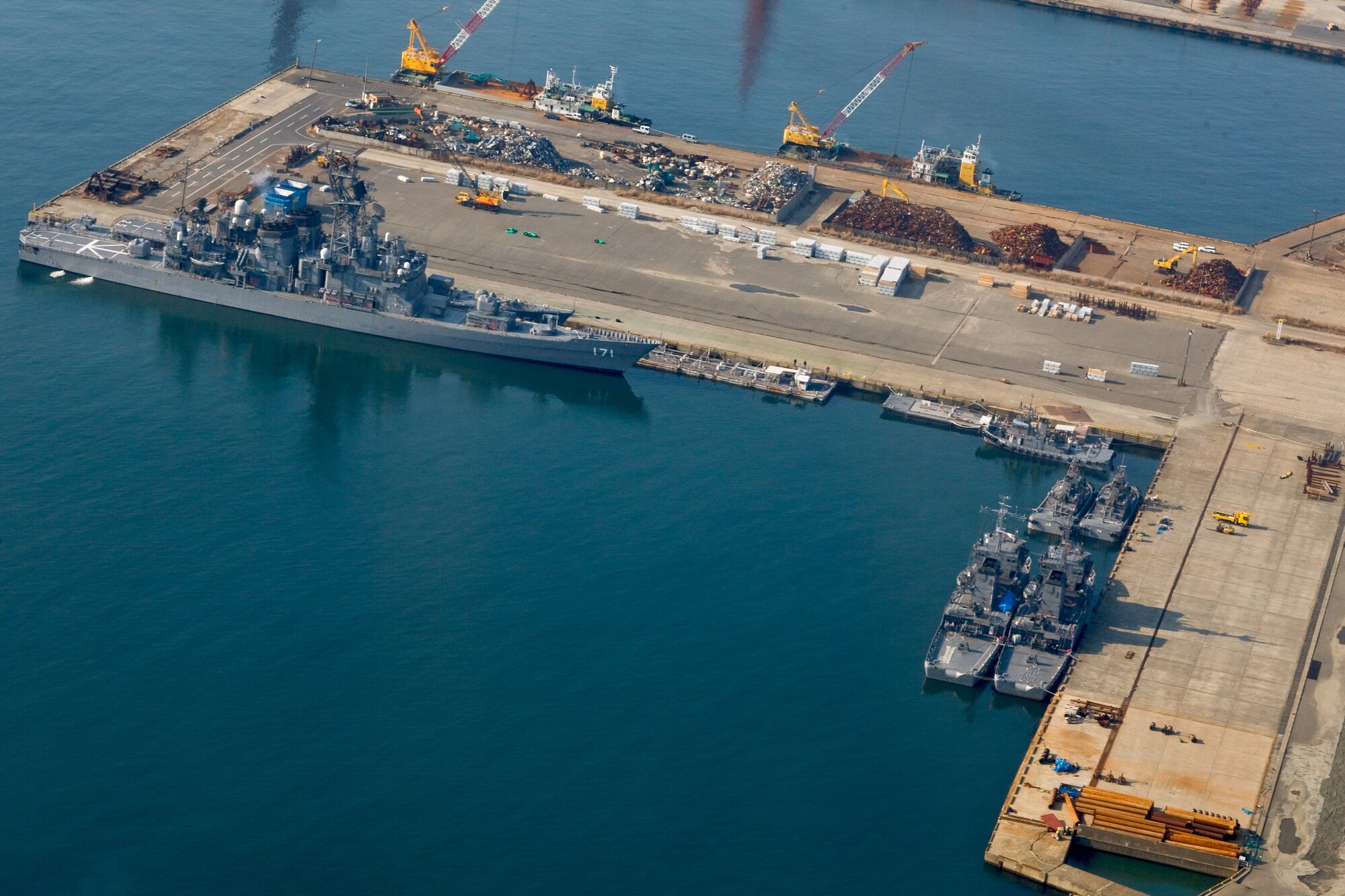 ONAHAMA, Japan -- A bilateral task force from the United States and Australia arrive to help Tokyo Electric Power Company employees complete a fresh water cooling system March 29, 2011.  The system of high pressure pumps and hoses will be used to spray freshwater from barges onto the Fukushima nuclear power plant. Japan Maritime Self-Defense Force vessels towed the barges full of freshwater from Yokosuka to the site.  Eight Yokota Airmen designed and created necessary adapters, pressure valves and other pieces of equipment to modify the pumps for the mission. (U.S. Air Force photo/Osakabe Yasuo)