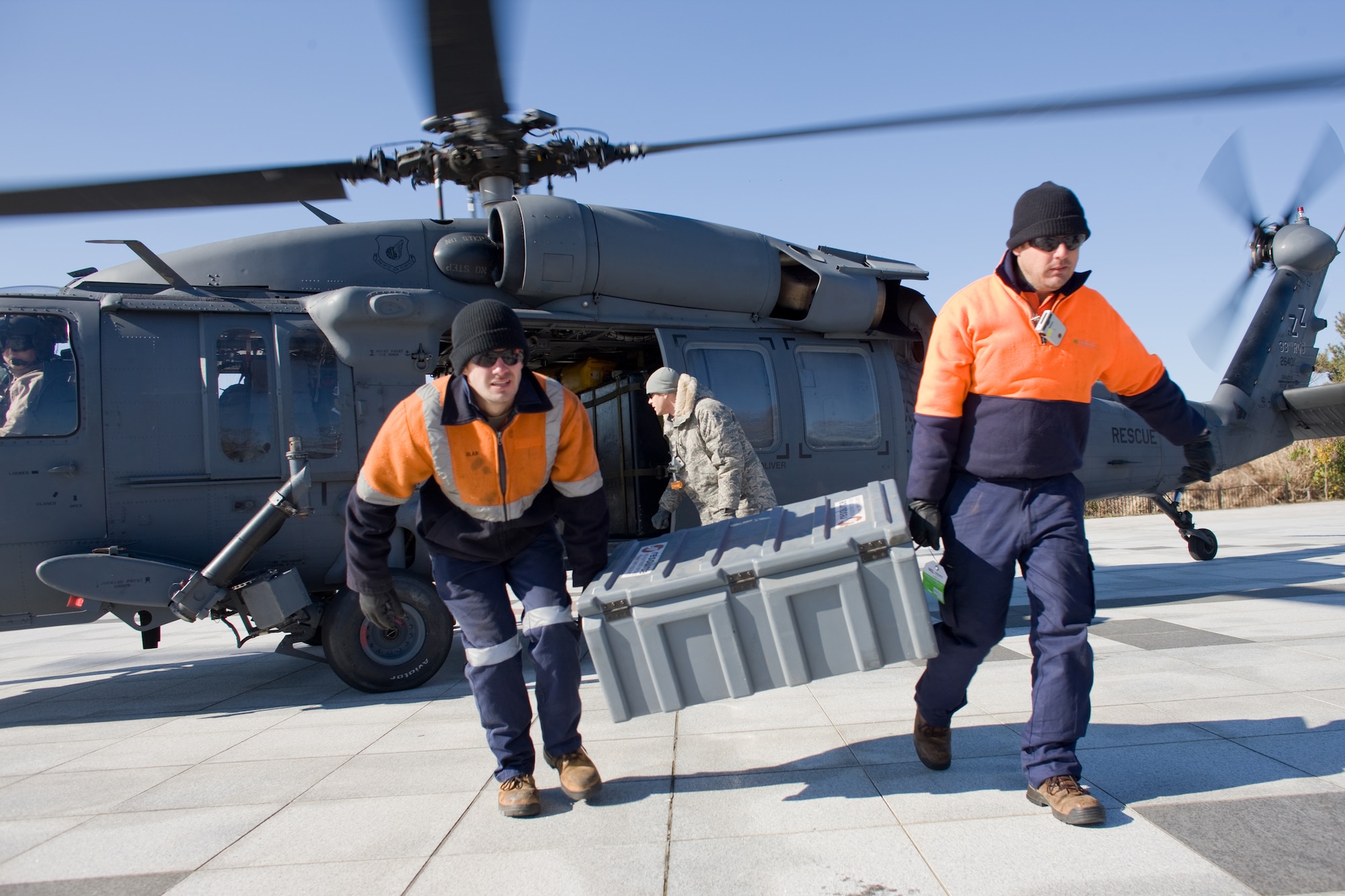 ONAHAMA, Japan -- Volunteers from Australia land at Onahama port, Fukushima Prefecture by HH-60 Pave Hawk March 28, 2011. A bilateral task force from the United States and Australia will help Tokyo Electric Power Company employees complete a fresh water cooling system.  The system of high pressure pumps and hoses will be used to spray freshwater from barges onto the Fukushima nuclear power plant. Japan Maritime Self-Defense Force vessels towed the barges full of freshwater from Yokosuka to the site.  Eight Yokota Airmen designed and created necessary adapters, pressure valves and other pieces of equipment to modify the pumps for the mission. (U.S. Air Force photo/Osakabe Yasuo)