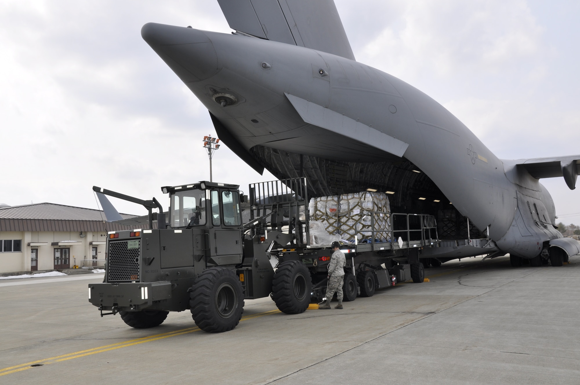 MISAWA AIR BASE, Japan -- Airmen unload pallets of water from a U.S. Air Force C-17 Globemaster III, here March 30. The aircraft delivered 87,000 pounds of bottled water in support of Operation Tomodachi. (U.S. Air Force photo by Senior Airman Joe McFadden/Released)