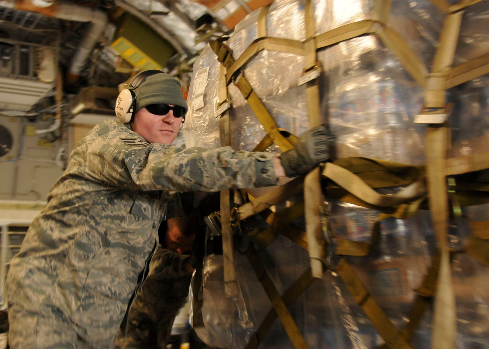 MISAWA AIR BASE, Japan -- Tech. Sgt. Damion Hankins, deployed from the 621st Contingency Response Wing at McGuire Air Force Base, N.J., unloads pallets of water from a U.S. Air Force C-17 Globemaster III, here March 30. Approximately 55 pallets of water have been delivered to Misawa Air Base to be used for Operation Tomodachi relief efforts. Sergeant Hankins is a native of Le Roy, Ill. (U.S. Air Force photo by Staff Sgt. Rachel Martinez/Released)