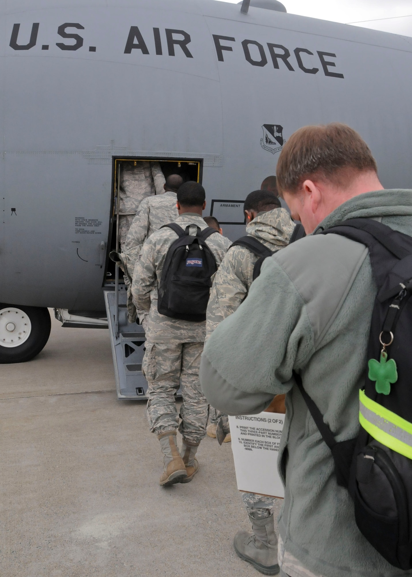 MISAWA AIR BASE, Japan -- Airmen line up to load a U.S. Air Force C-130 Hercules on the flightline here March 30. The 42 Airmen from the 18th Civil Engineer Squadron at Kadena Air Base augmented the 35th Civil Engineer Squadron with base recovery efforts following the March 11 earthquake. (U.S. Air Force photo by Staff Sgt. Rachel Martinez/Released)