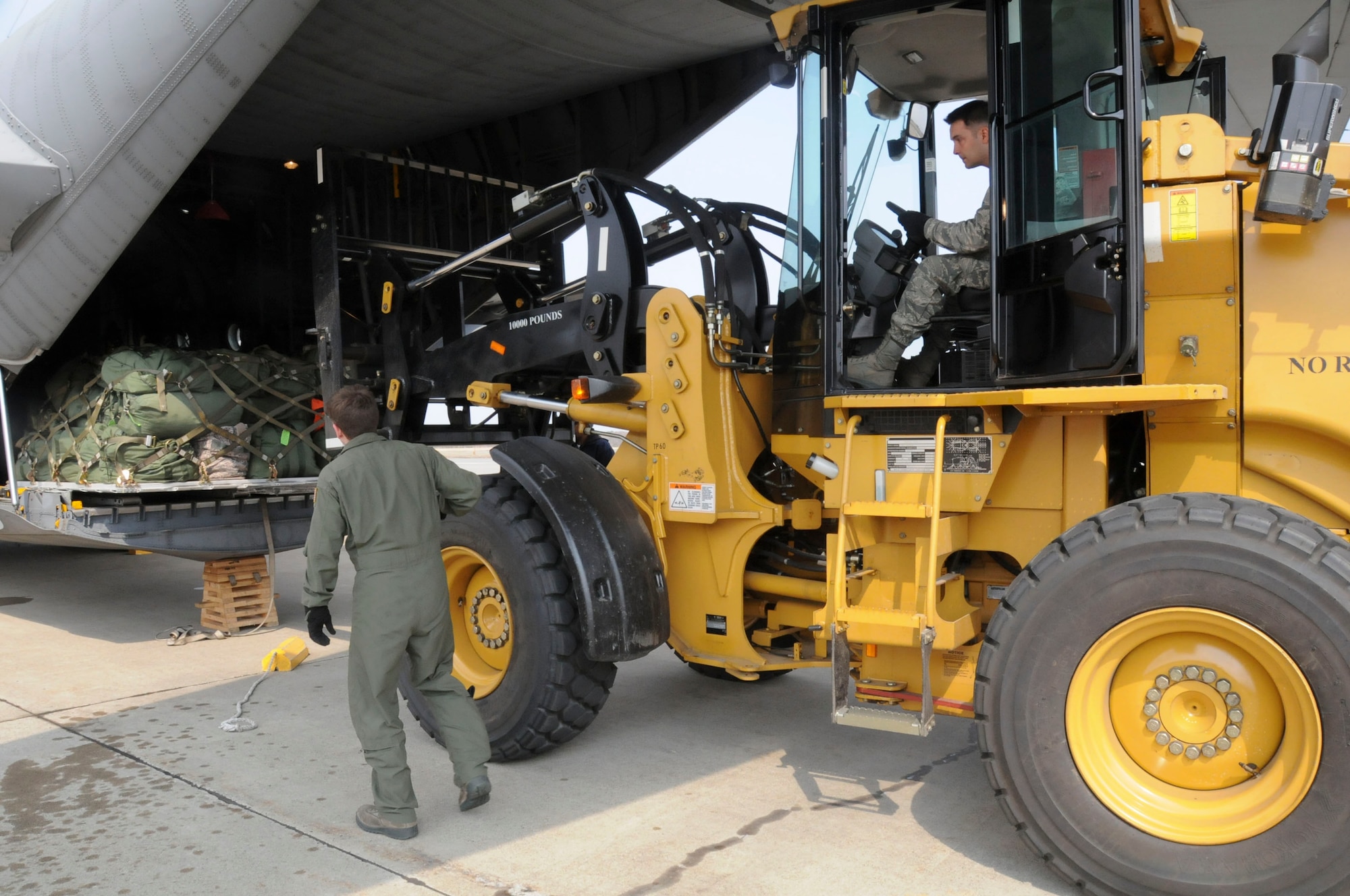 MISAWA AIR BASE, Japan -- Staff Sgt. Stewart Guethlein, a loadmaster with the 36th Airlift Squadron from Yokota Air Base, directs a forklift carrying baggage onto a U.S. Air Force C-130 Hercules here March 30. The baggage belonged to a group of 42 civil engineers who redeployed to Kadena Air Base after augmenting the 35th Civil Engineer Squadron to help the base recover from the March 11 earthquake which took out power and caused minor facility damage. (U.S. Air Force photo by Staff Sgt. Rachel Martinez/Released)