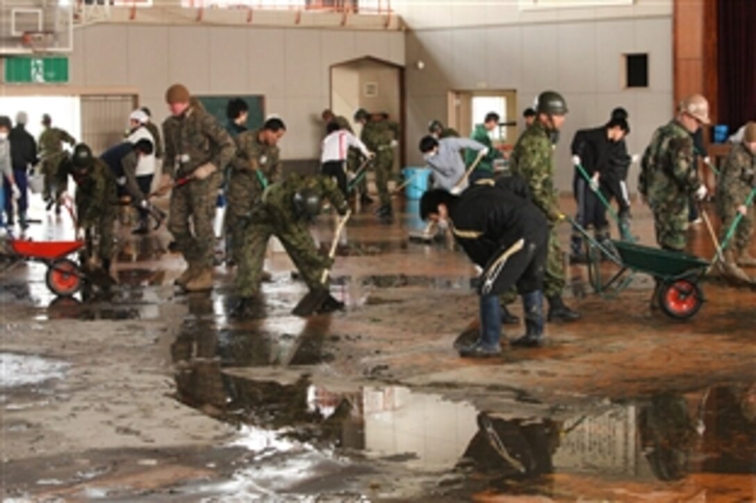 U.S. service members, members of the Japan Self-Defense Force and students of Ishinomaki High School work together to clean the school during Operation Field Day in Ishinomaki, Japan, March 30, 2011. U.S. service members are working with their Japanese counterparts to provide assistance in support of Operation Tomodachi. 