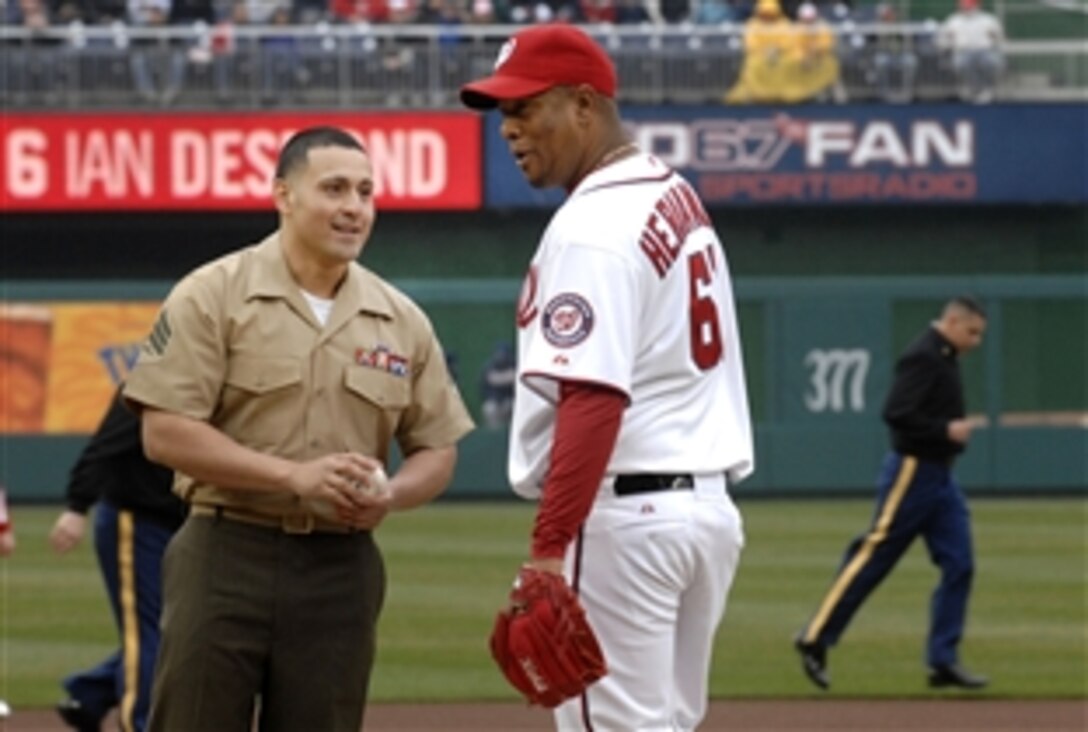 U.S. Marine Corps Sgt. Gabriel Ledesma, left, delivers the game ball to Washington Nationals' opening day starting pitcher Livan Hernandez at Nationals Park in Washington, D.C., March 31, 2011. Ledesma and several other wounded warriors and Iraq and Afghanistan war veterans participated in the Nationals' 2011 season opener against the Atlanta Braves.