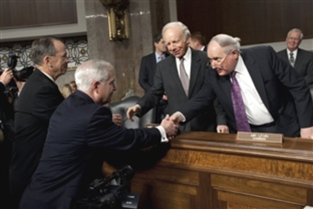 Navy Adm. Mike Mullen, left, chairman of the Joint Chiefs of Staff, and Defense Secretary Robert M. Gates, right, greet Sen. Joseph I. Lieberman and Sen. Carl Levin before a Senate Armed Services Committee hearing on operations in Libya at the Dirksen Senate Office Building in Washington, D.C., March 31, 2011.
