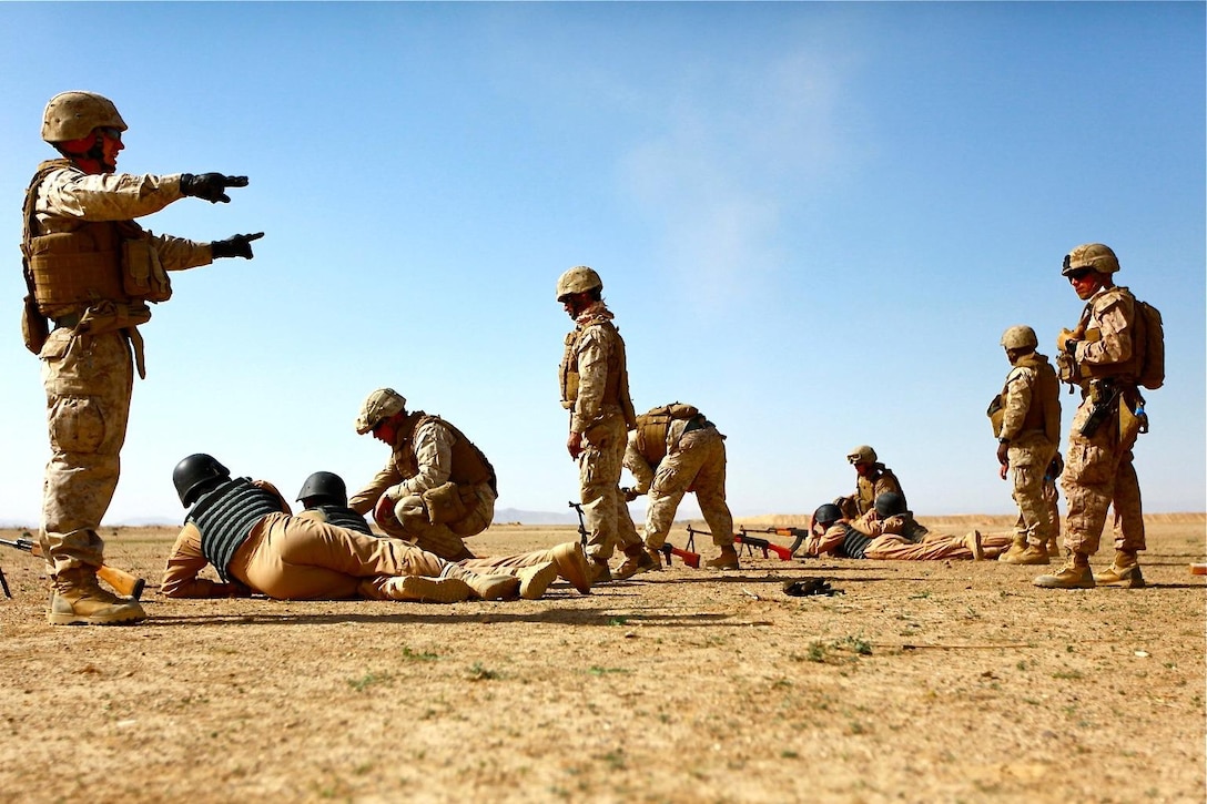 Marines help Afghan National Security Forces set up their weapons during the non-commissioned officer course at Joint Security Academy Southwest aboard Camp Leatherneck, March 31.