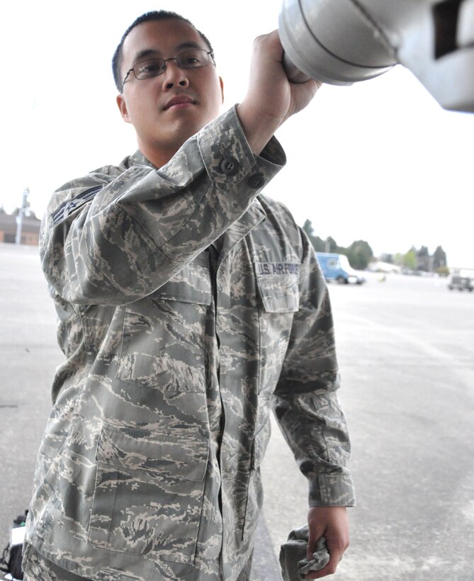 Air Force Senior Airman Jalearnchi Sirisin, an aircraft hydraulic technician journeyman with the 446th Aircraft Maintenance Squadron, McChord Field, Wash., juggles the struts (one of an aircraft's many landing gear components) to see how much excess play (how much it moves) it has. Aircraft hydraulic technicians, like Airman Sirisin, stand for long periods of time, inspecting each C-17 Globemaster III aircraft component, troubleshooting, removing, repairing, overhauling, and installing aircraft hydraulic systems and components. The Lacey, Wash., resident said aircraft hydraulic technicians must be detail oriented and have a sense of humor. (U.S. Air Force Photo/SSgt. Nicole Celestine)